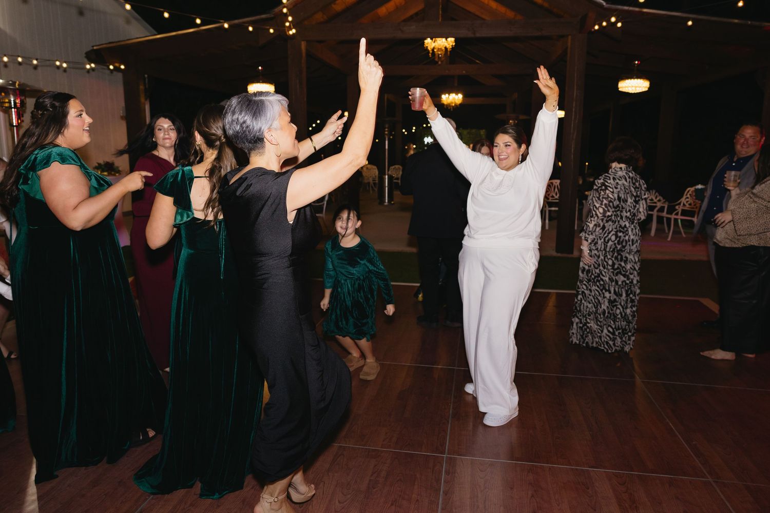 Guests dancing joyfully on the dance floor at a wedding reception.