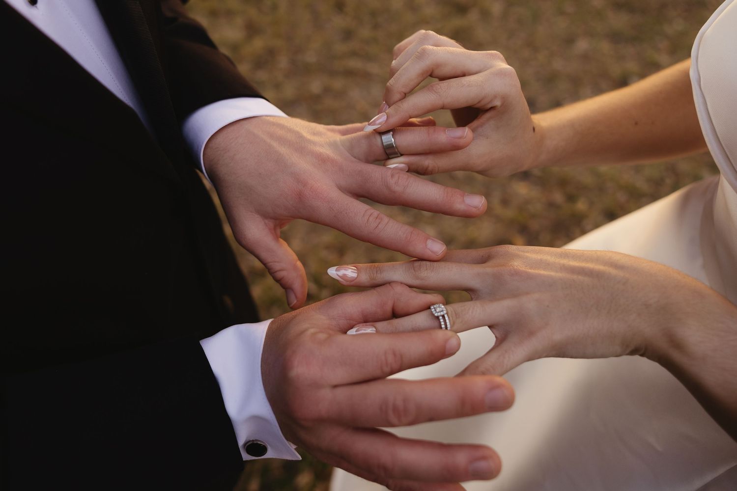 Close-up of a bride and groom exchanging wedding rings during their marriage ceremony.