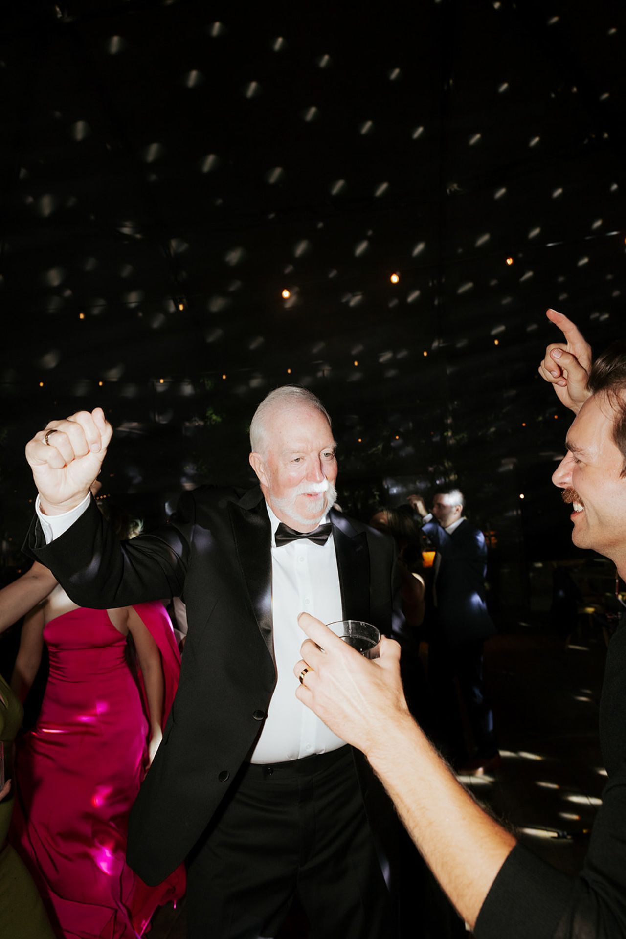 A sequence of photos showing two people dancing together at a formal event in a dark room.