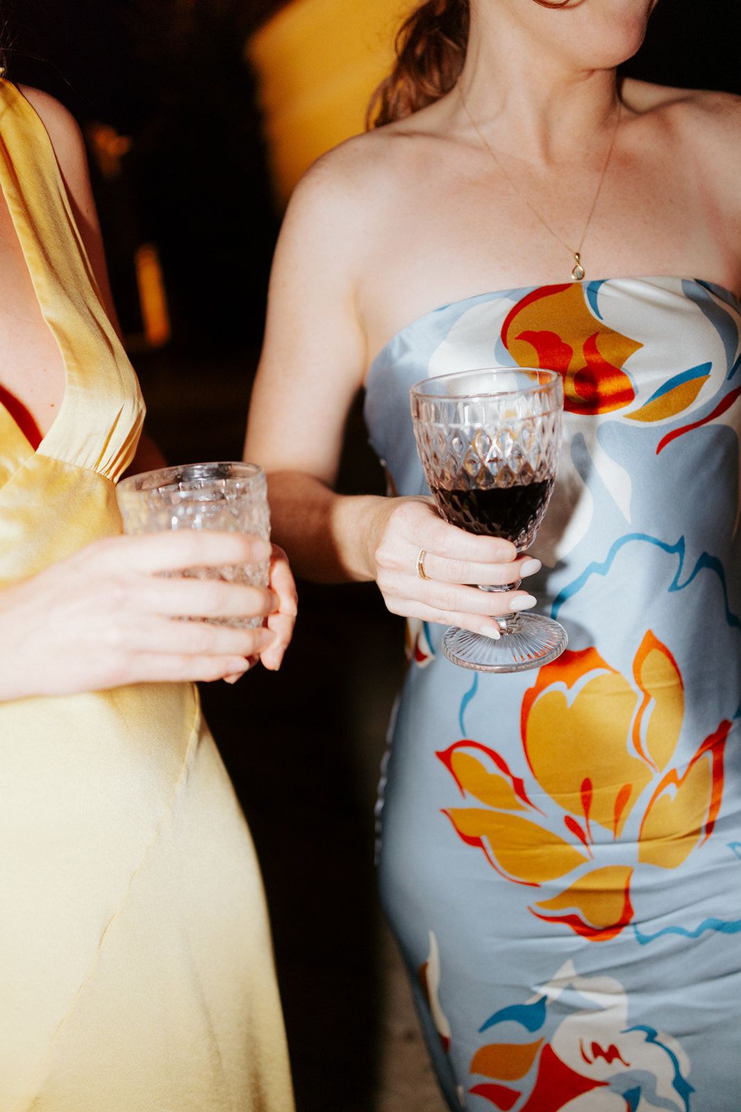 Series of wedding party attendants in yellow and blue dresses holding crystal glasses at a reception.
