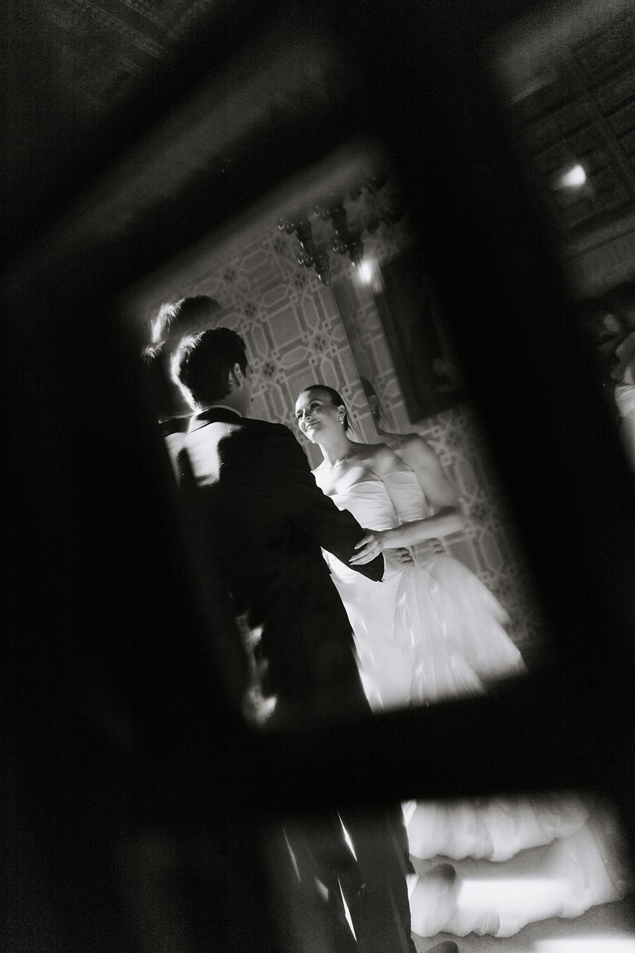 A dramatic black and white performance photo shows a figure in contrasting light and shadow on stage.