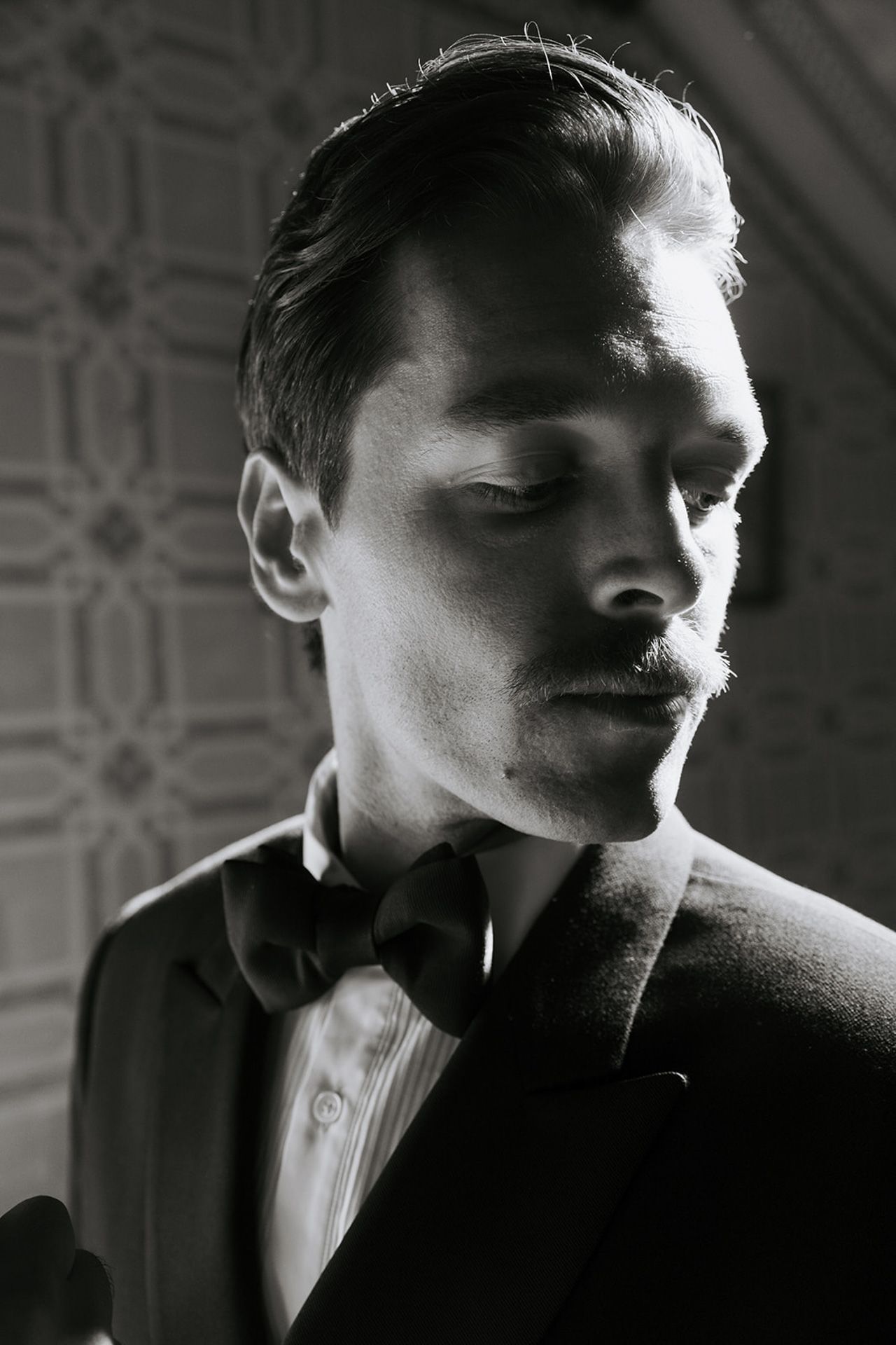 Dramatic black and white portraits showing someone in formal attire with moody lighting and shadows.