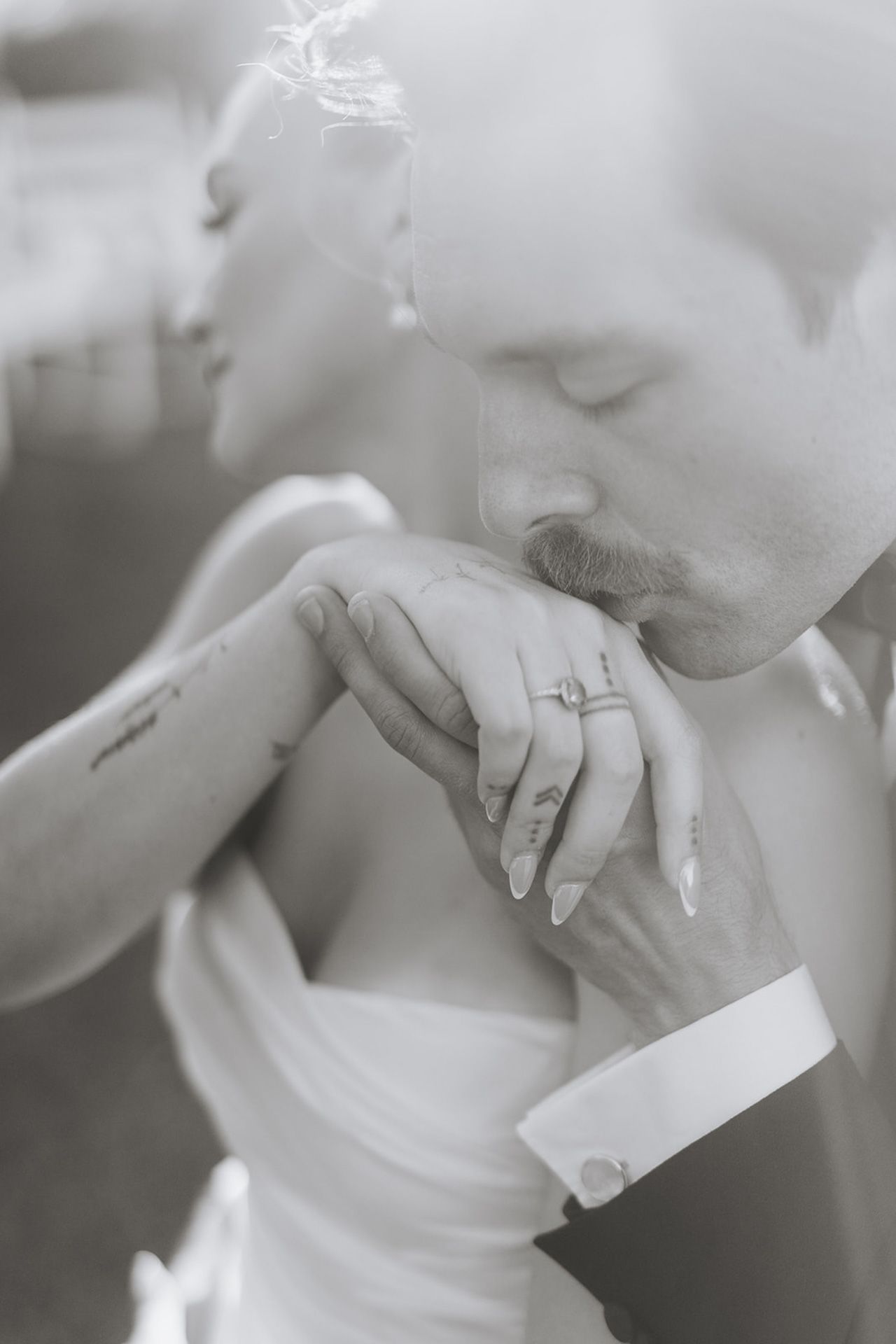 A black and white photo sequence shows hands holding and opening an envelope with a ring visible.