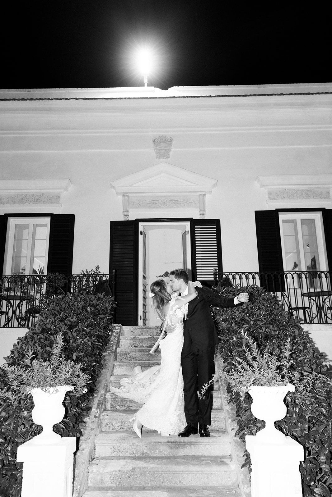 Black and white negative sequence showing figures standing on a white porch with bushes and windows.