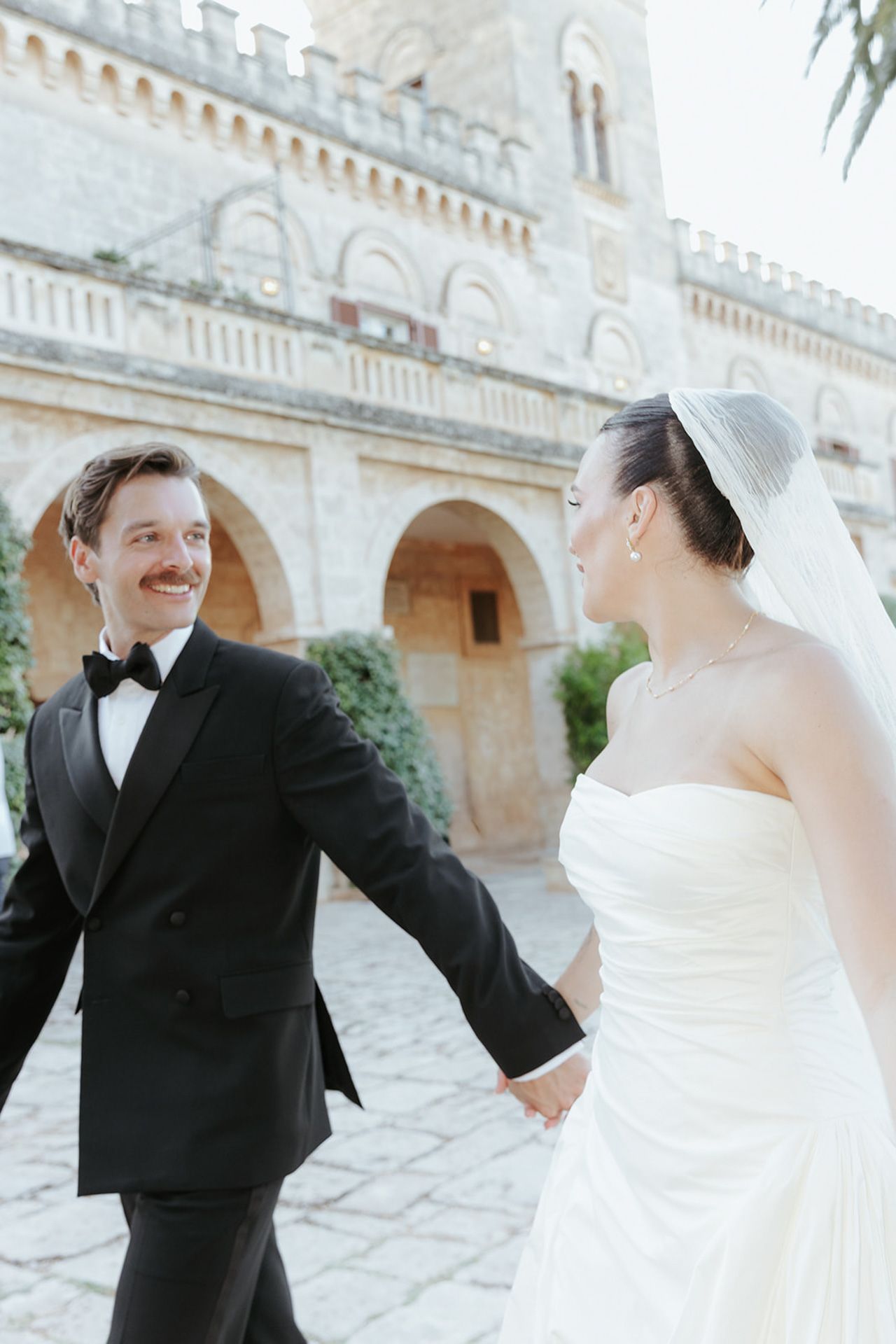 A series of candid wedding moments captured in front of an elegant castle with classic architecture.