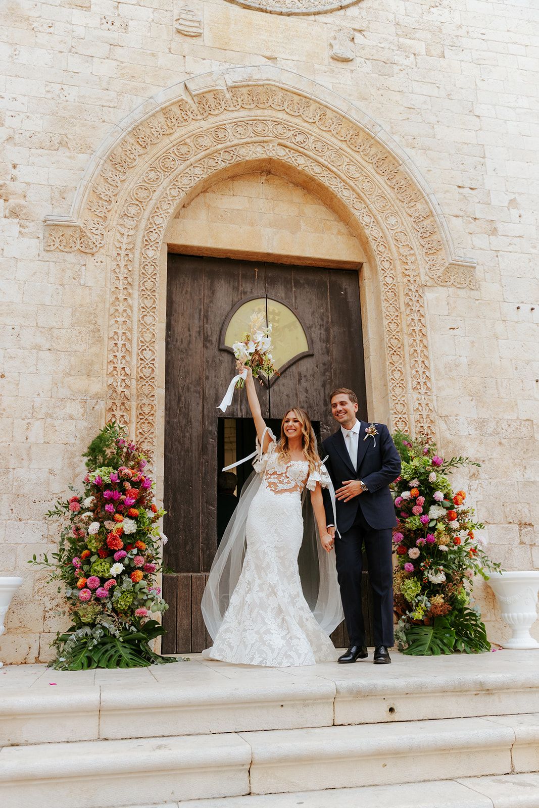 A series of elegant wedding moments captured in front of an ornate stone church doorway with floral arrangements.