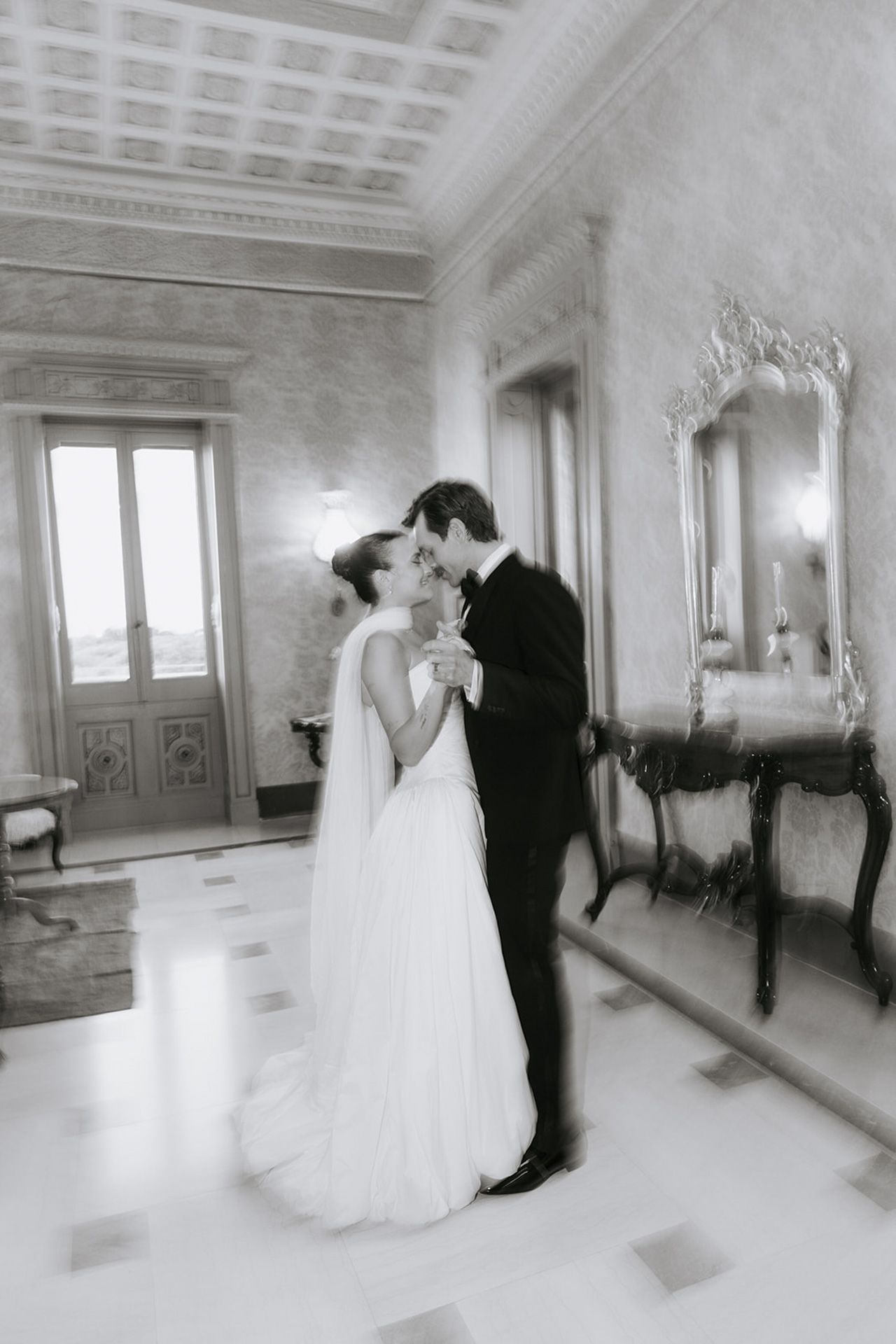 Elegant black and white wedding sequence showing couple dancing in ornate ballroom with decorative moldings.
