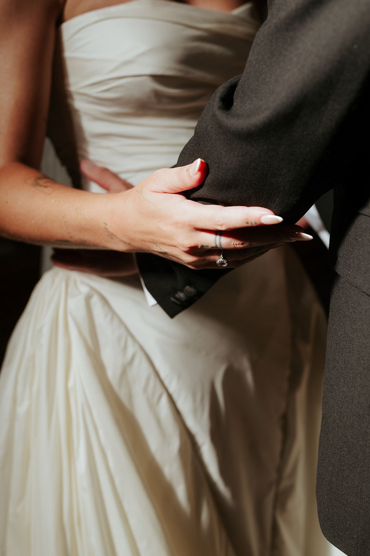 Close-up sequence showing hands exchanging wedding rings during a marriage ceremony with white dress and dark suit.