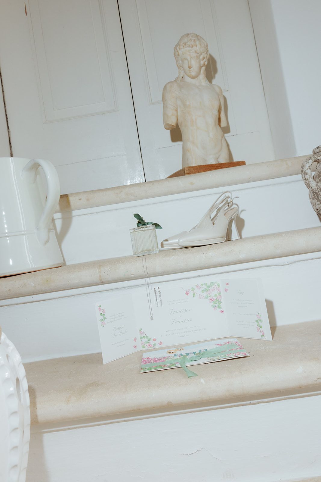 A series of white plaster classical busts displayed on floating wall shelves in a bright minimalist interior.