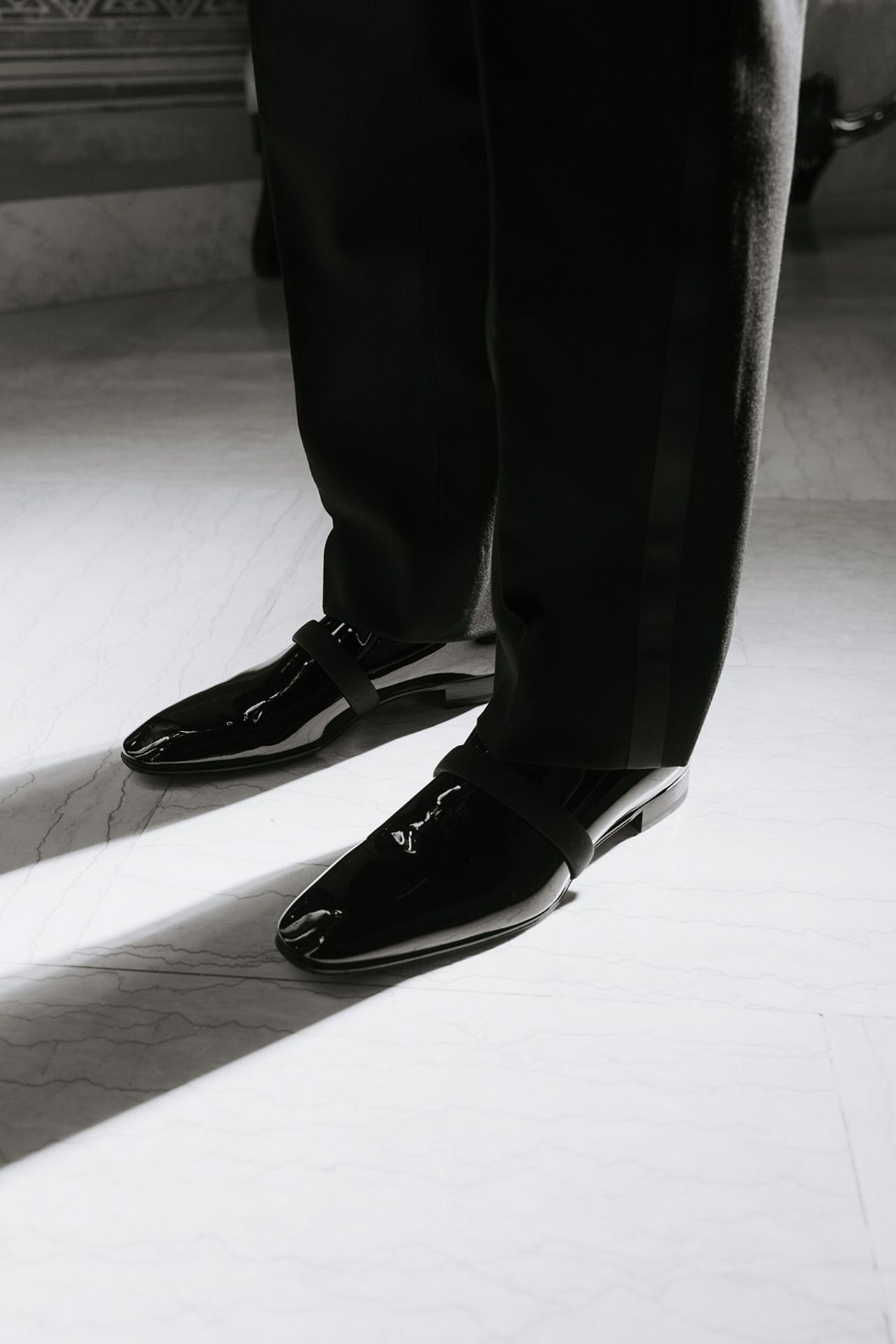 Black and white series of formal dress shoes walking on a light colored floor.
