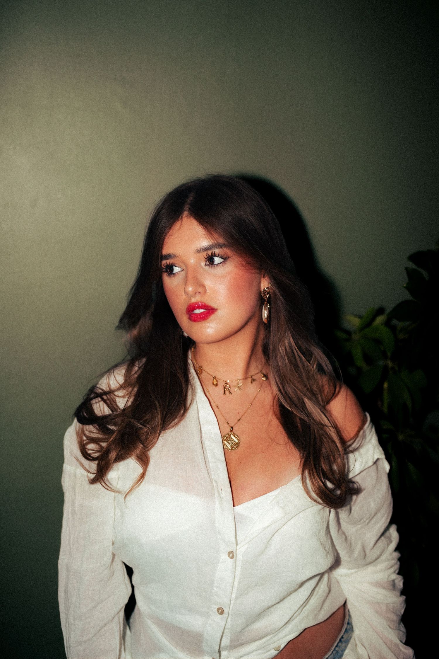 Artistic portrait in white button-down shirt with bold red lipstick against dark background. Harwich, Essex.