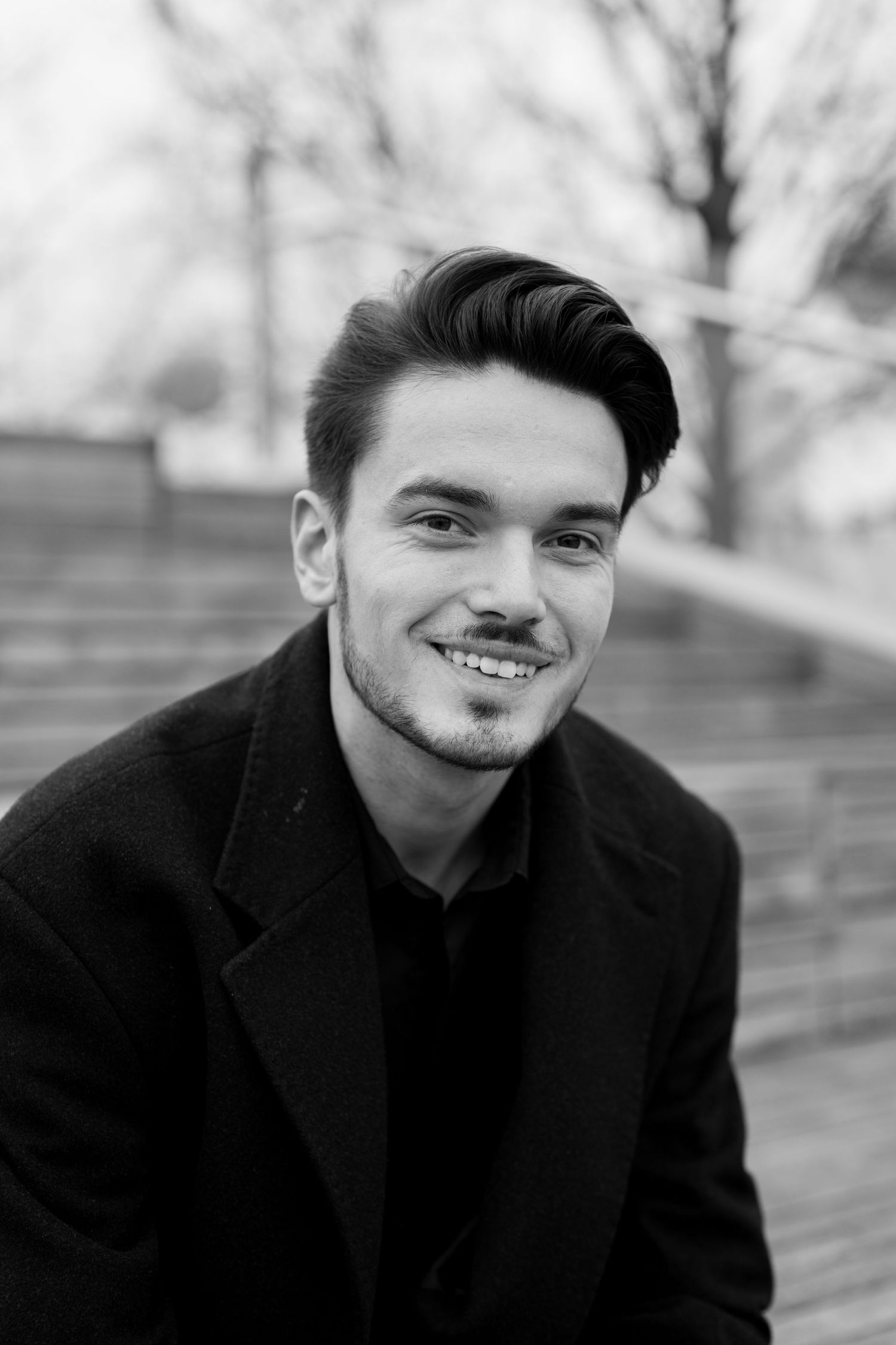 Black and white portrait with natural lighting and casual expression. London, UK.