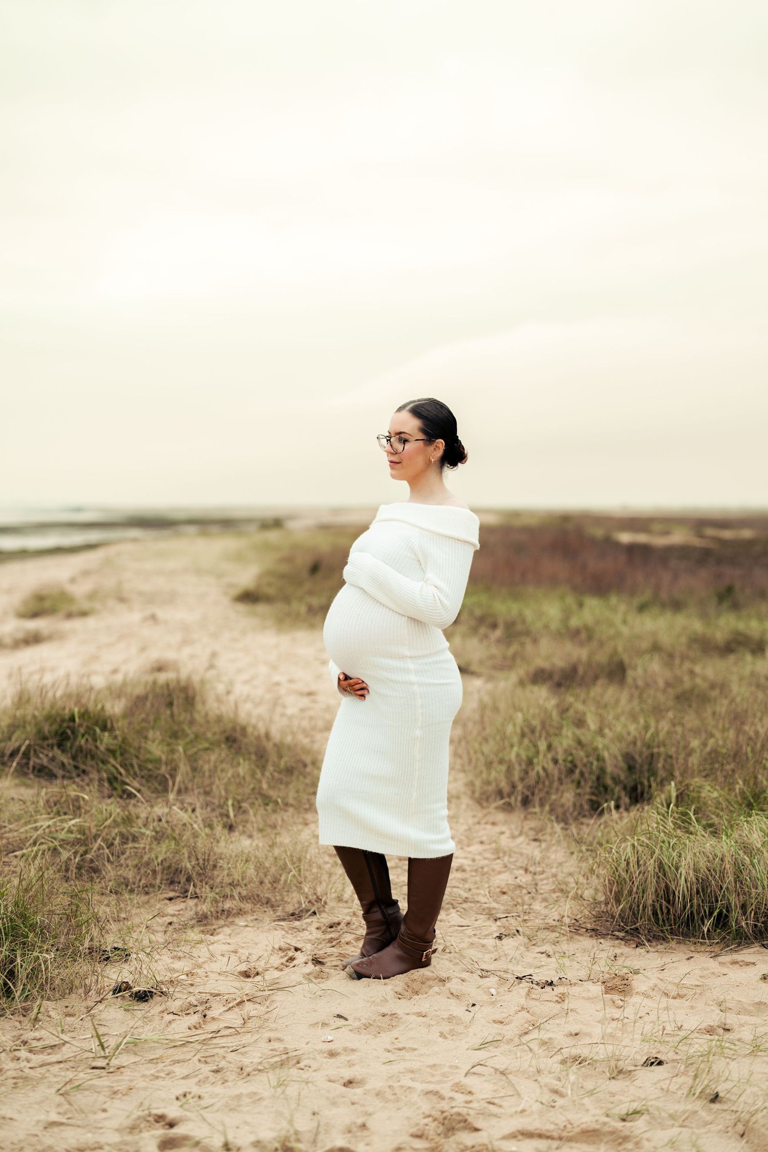 Person in white sweater exploring sandy coastal terrain. Earlhams Beach, Harwich, Essex.