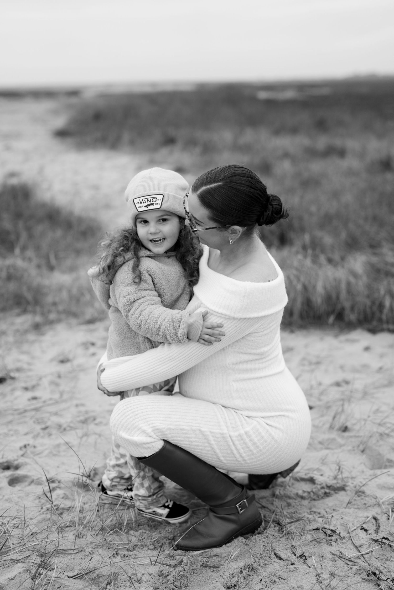 Tender moment shared on sandy dunes in black and white photography. Earlhams Beach, Harwich, Essex.