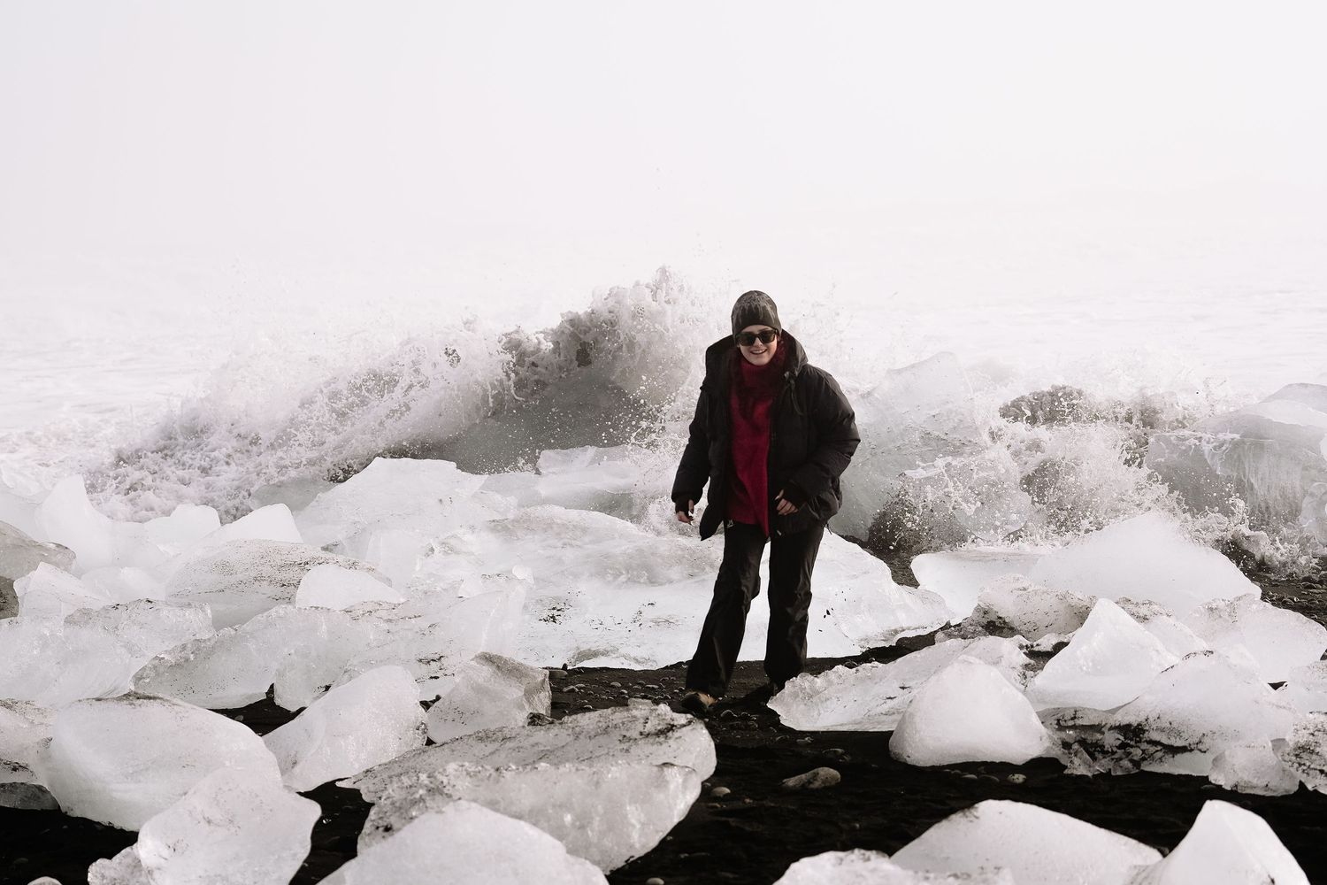 Winter adventurer explores dramatic ice formations along a frozen shoreline. Iceland.