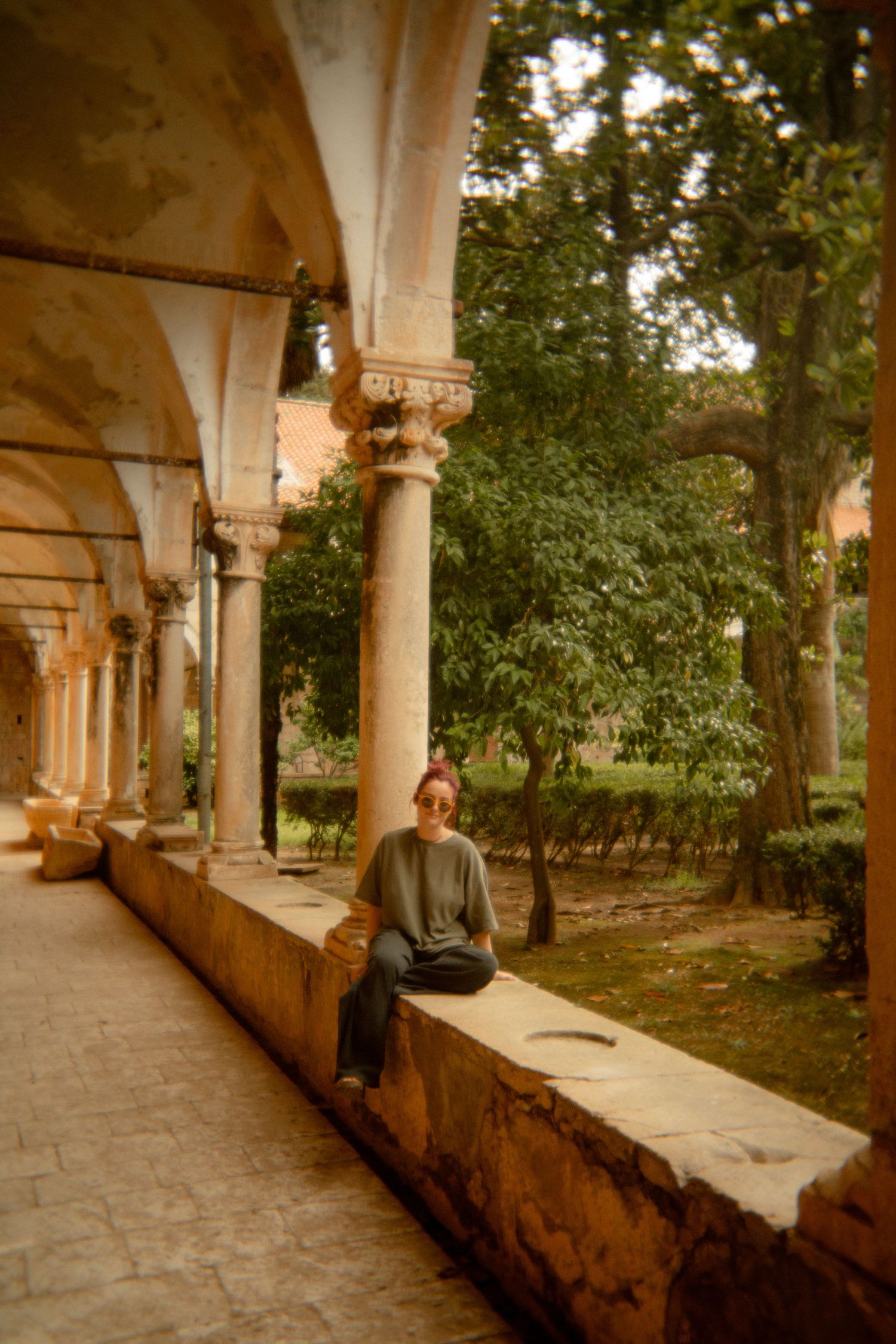 Ornate colonnade walkway with classical architecture overlooking a garden. Croatia.