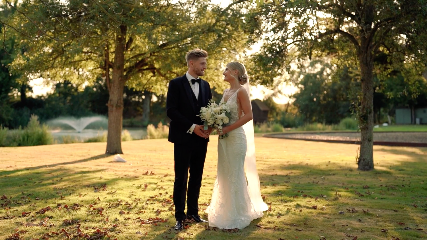 Wedding ceremony photos taken during golden hour under large trees in a park. Villiers Barn, Thorpe Le Soken.