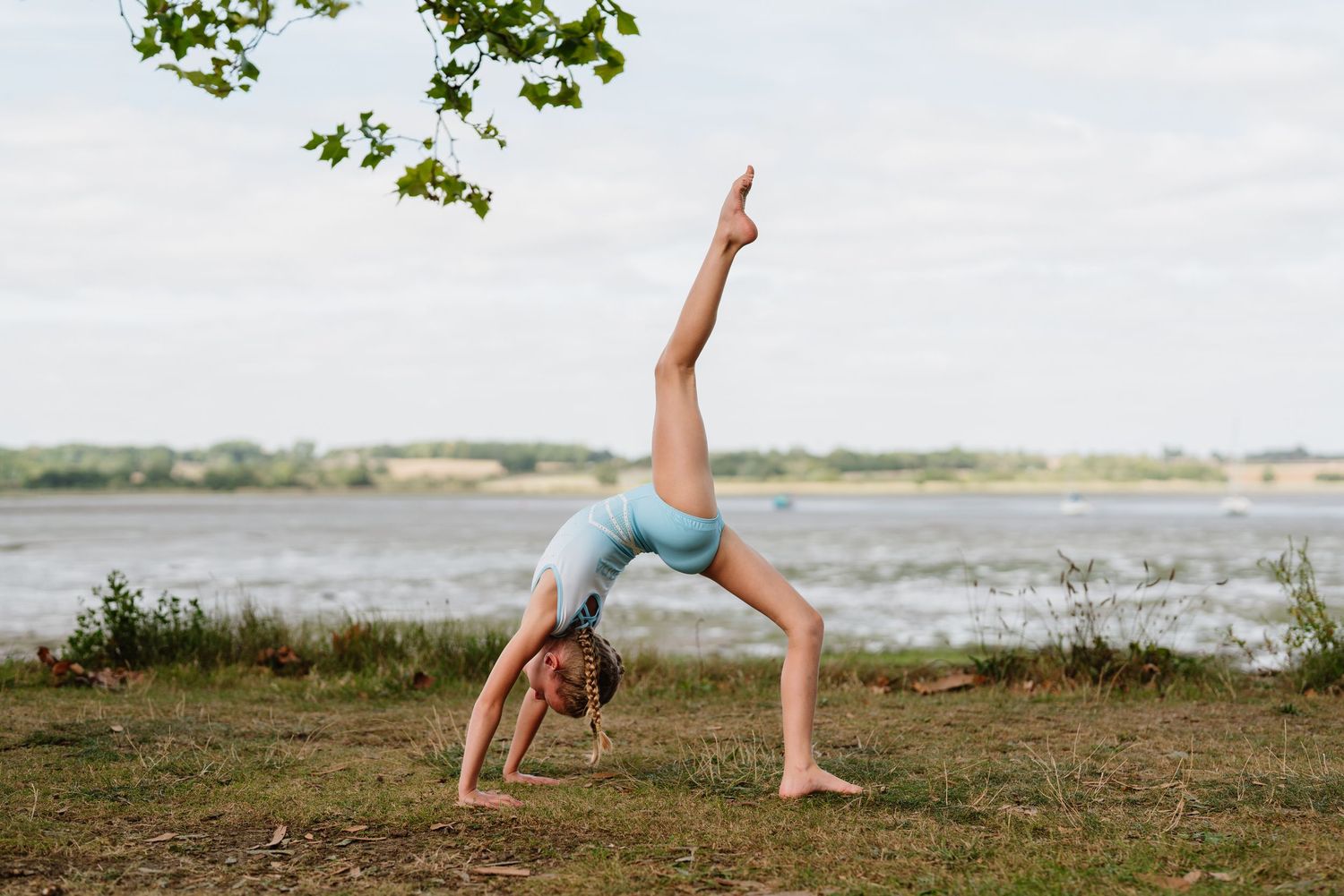 Dance movements performed in an outdoor setting with water and trees in the background. Manningtree, Essex.