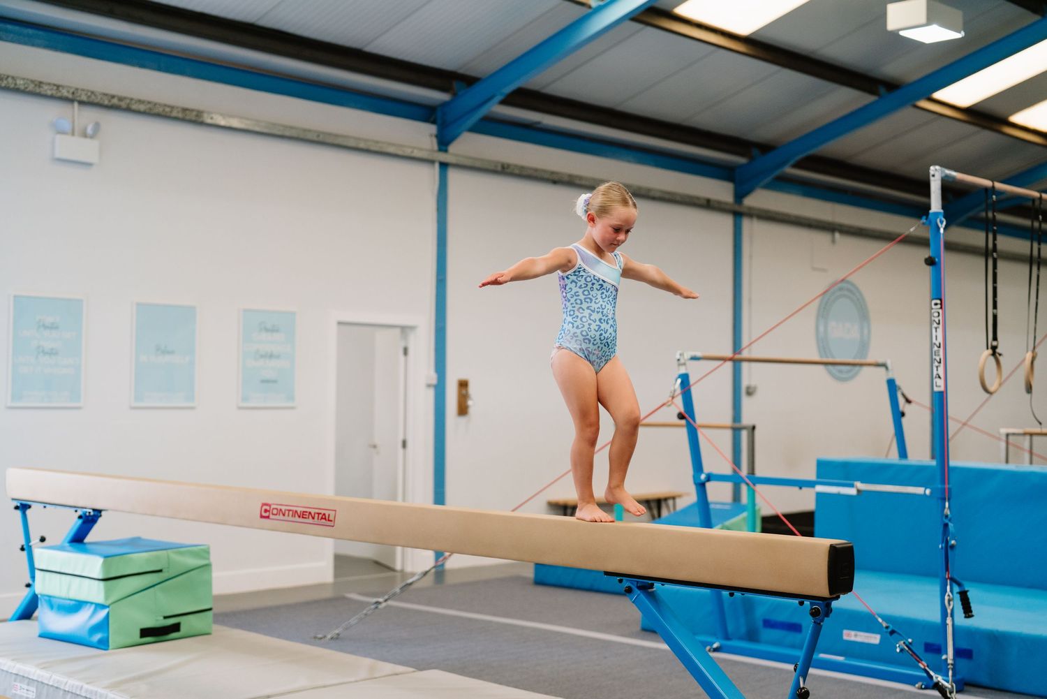 Young gymnast practicing balance on a beam during training session. Manningtree, Essex.