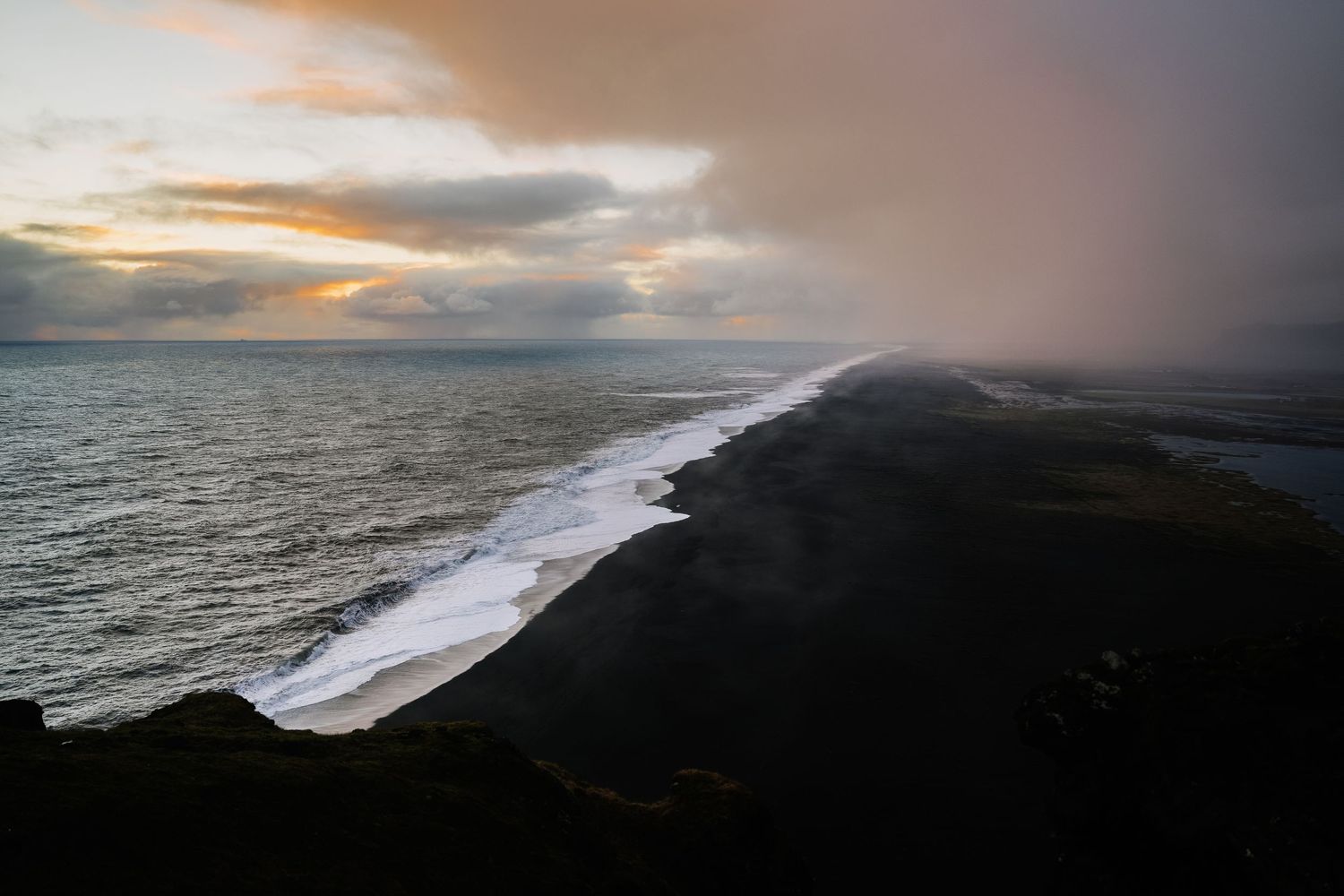 Dramatic aerial view of ocean waves crashing against a rocky coastline during sunset. Iceland.