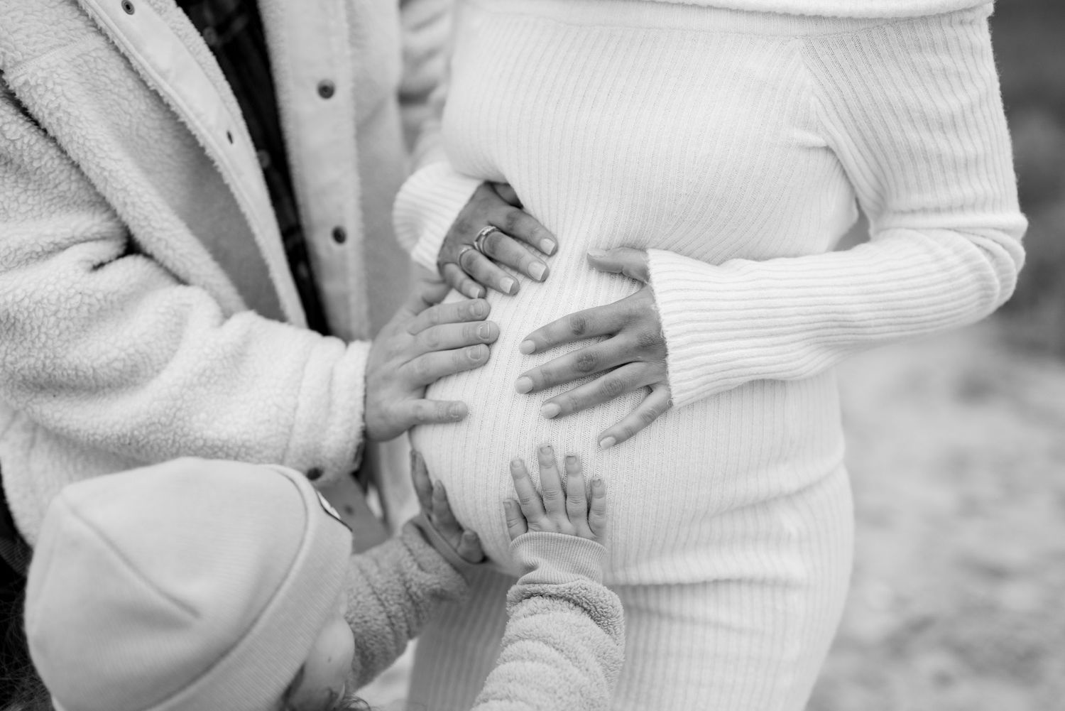 Close-up shots of couple embracing in white winter clothing outdoors. Earlhams Beach, Harwich, Essex.