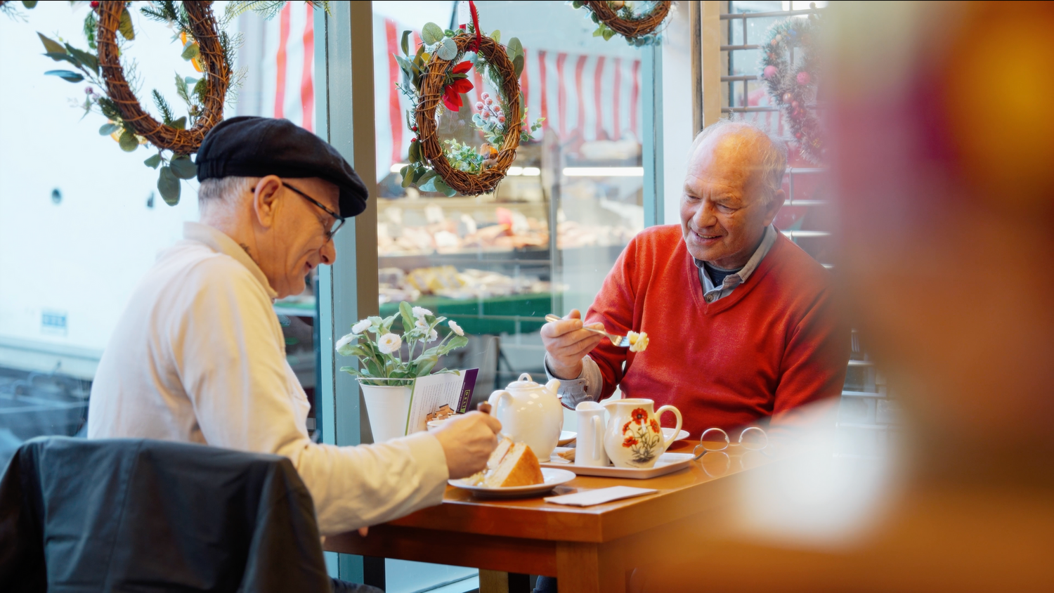 People dining in a casual restaurant decorated with festive holiday garlands. Dovercourt, Essex.