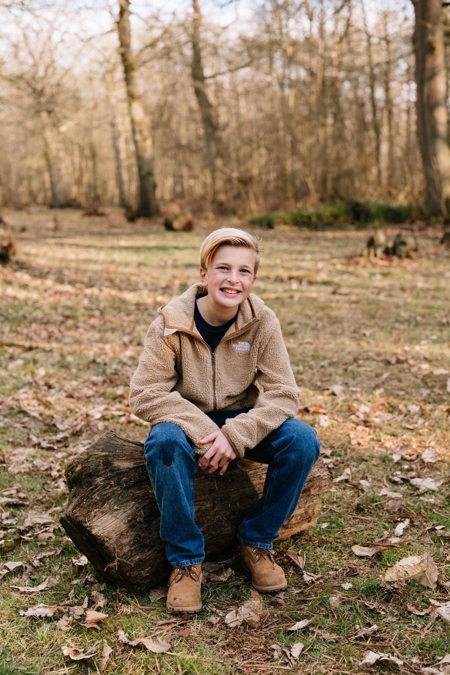 Portrait series of someone sitting on fallen logs in an autumn forest setting. Wrabness Woods, Essex.