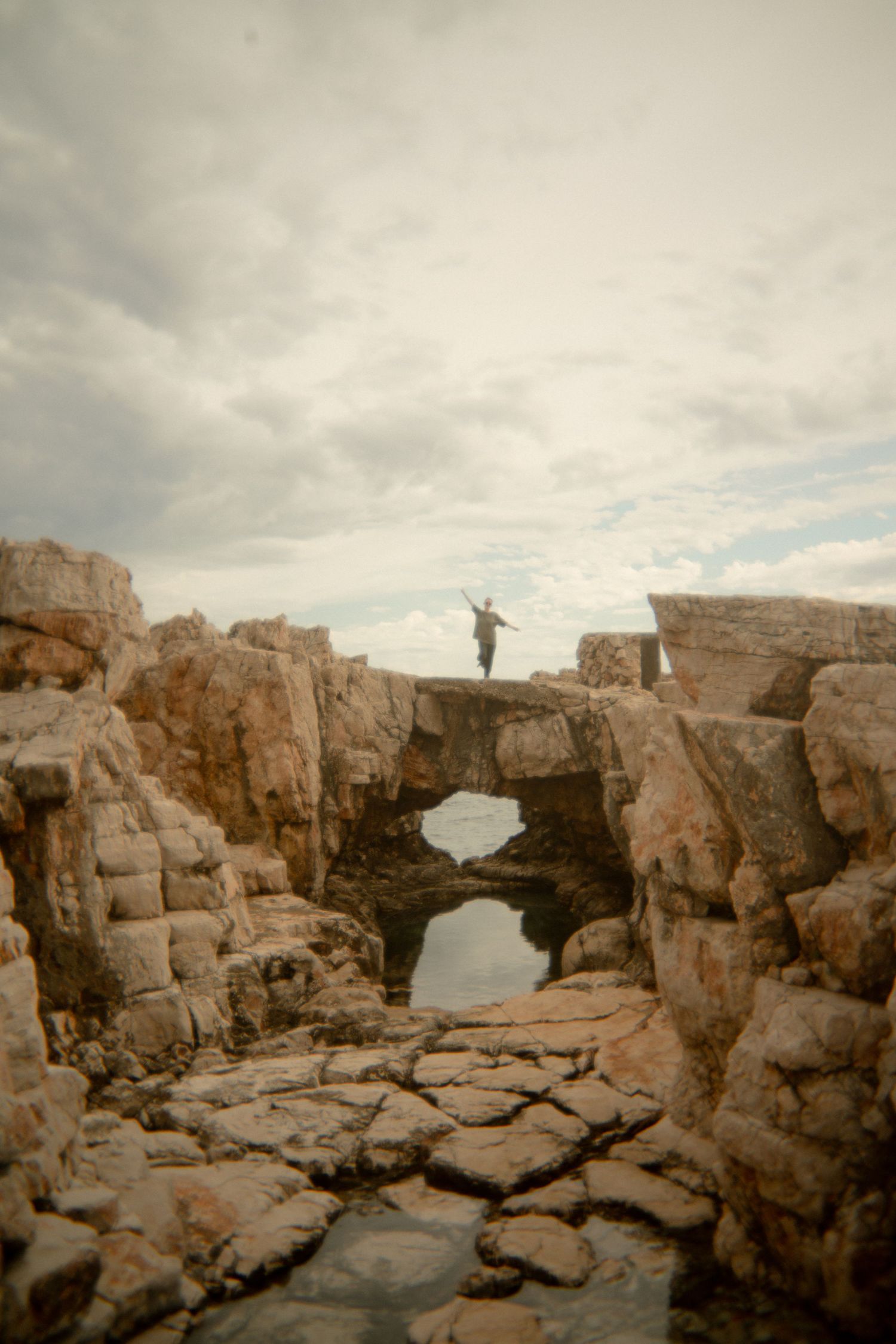 Rocky coastal formation with natural stone bridges over water. Croatia.