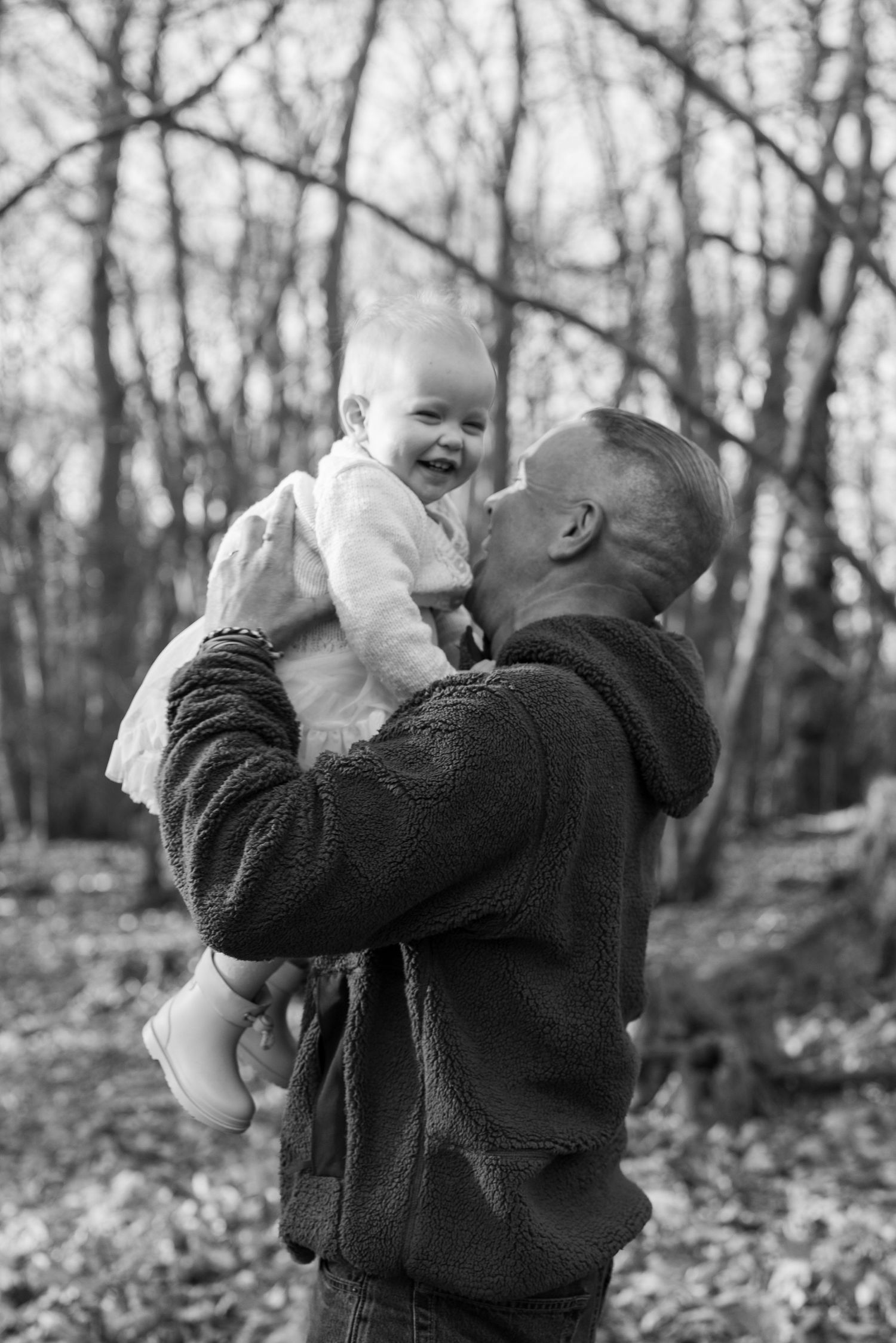 Joyful moments captured between parent and baby during an outdoor photo session. Wrabness Woods, Essex.