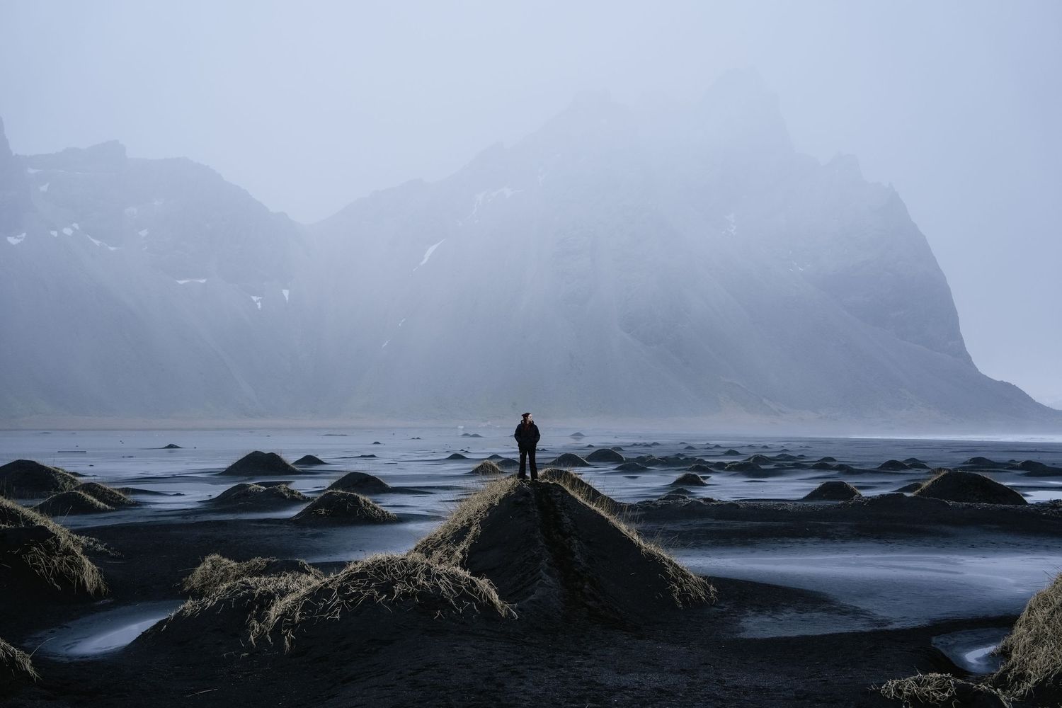 Dramatic coastal landscape with rugged cliffs and misty mountains meeting the ocean at sunset. iceland.