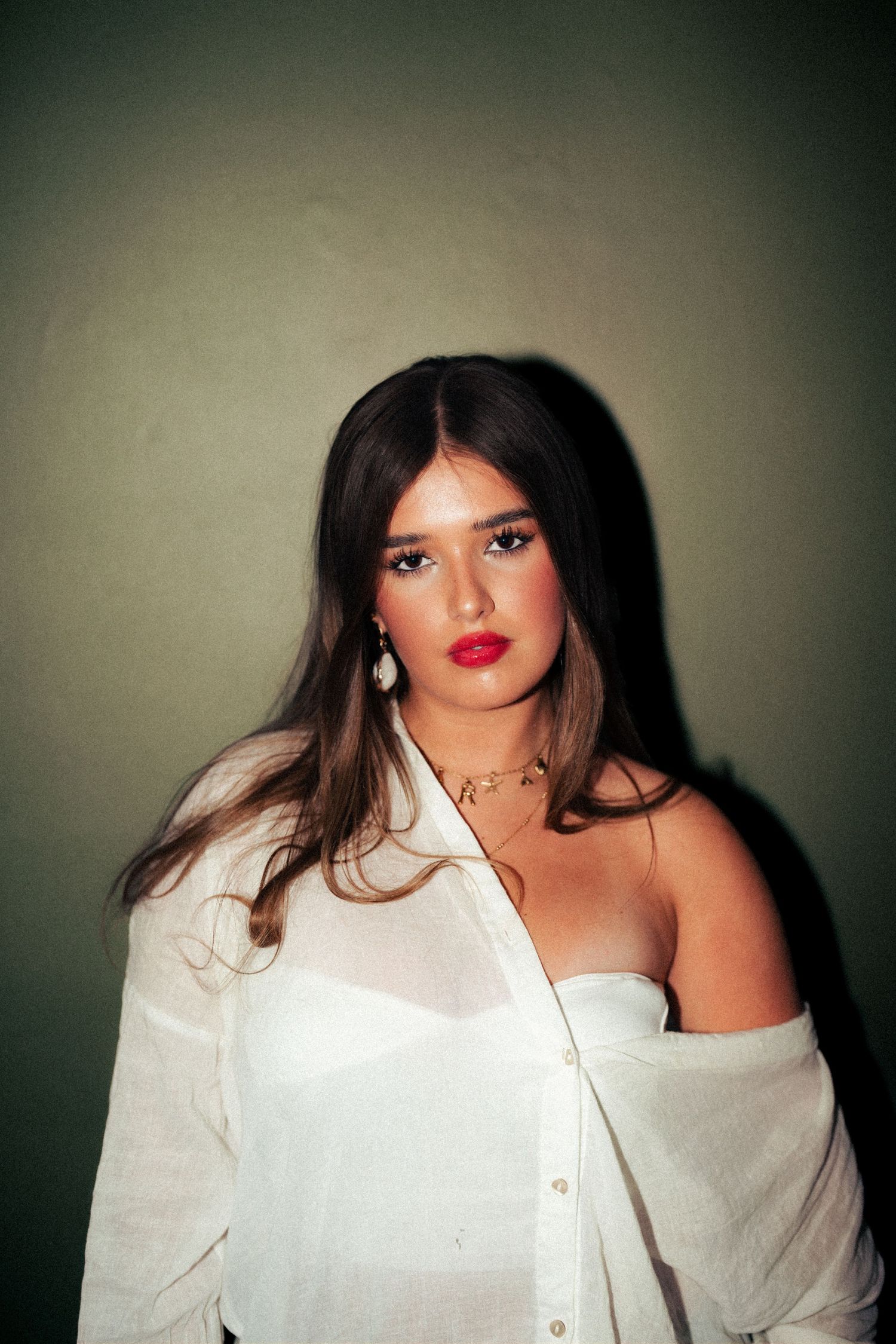 Portrait in white button-down shirt against moody dark background. Harwich, Essex.