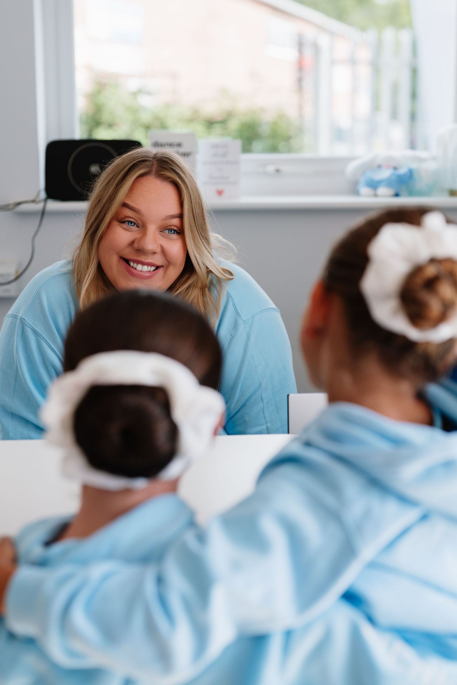 Students in light blue uniforms gathered during gymnastics training session. Manningtree, Essex.