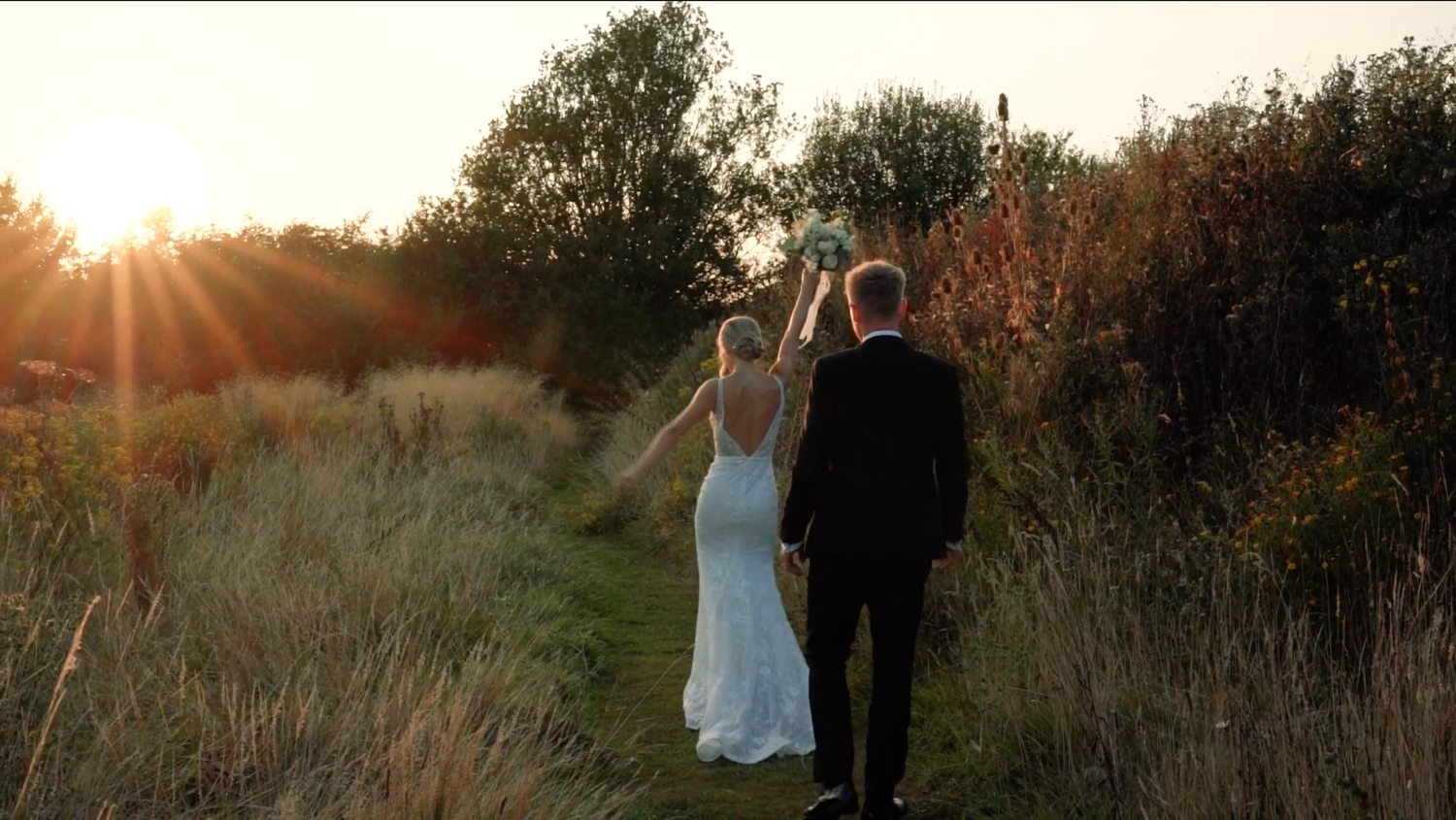 Wedding couple poses in a rustic field during sunset with natural landscape. Villiers Barn, Thorpe Le Soken.