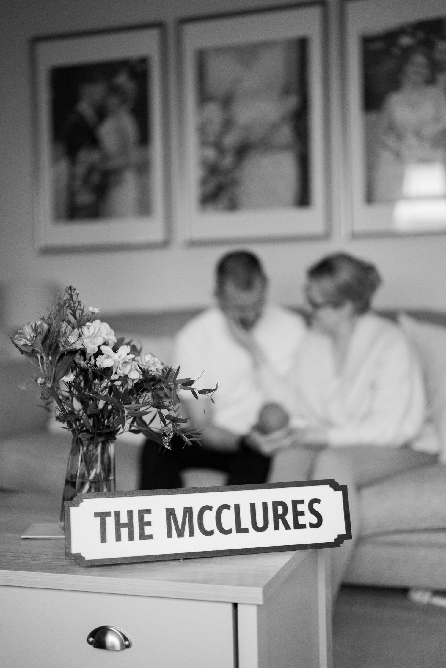 Wedding reception table with name card reading 'The McClures' and floral arrangements.