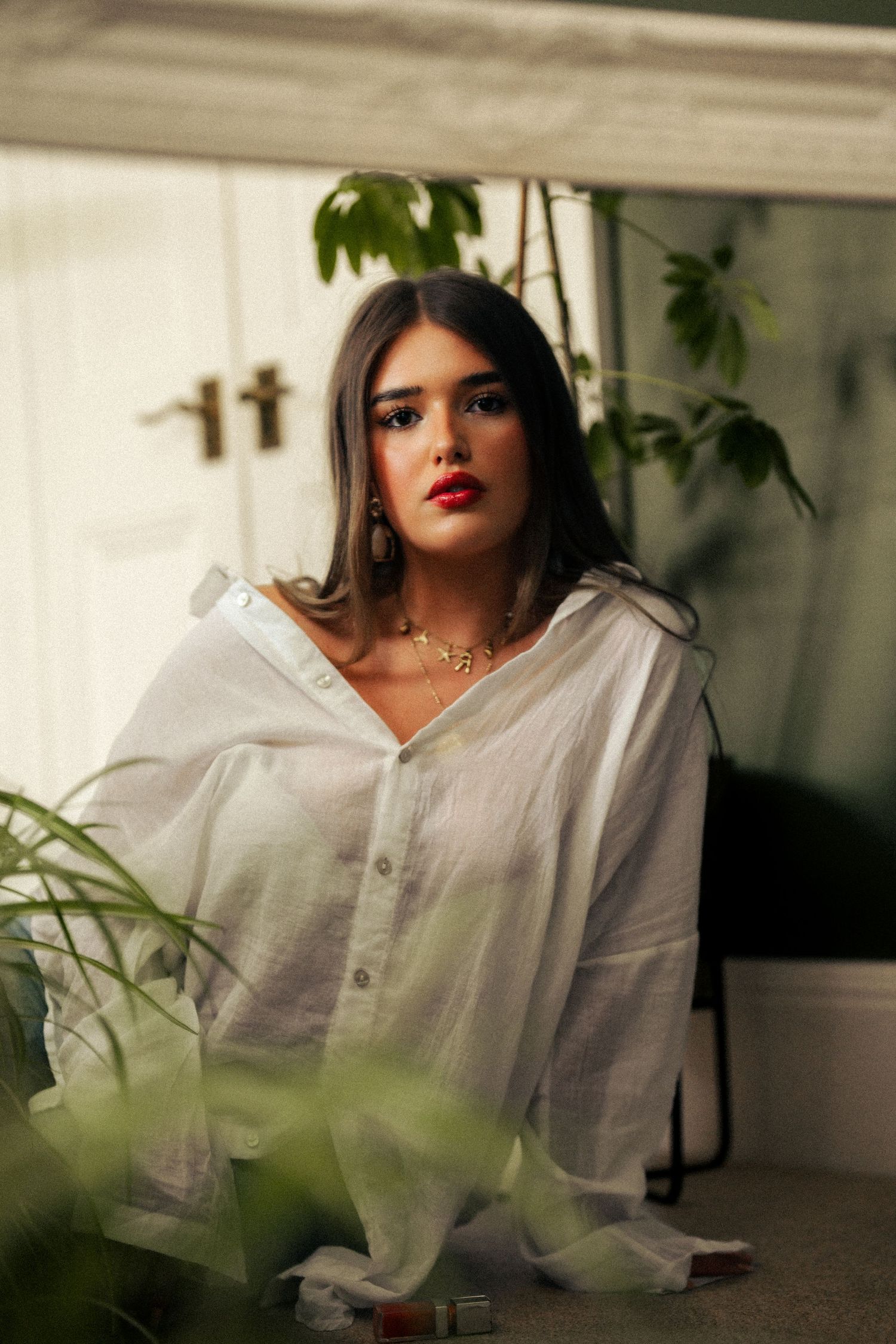 Fashion portraits through foliage featuring white shirt and bold makeup. Harwich Essex.