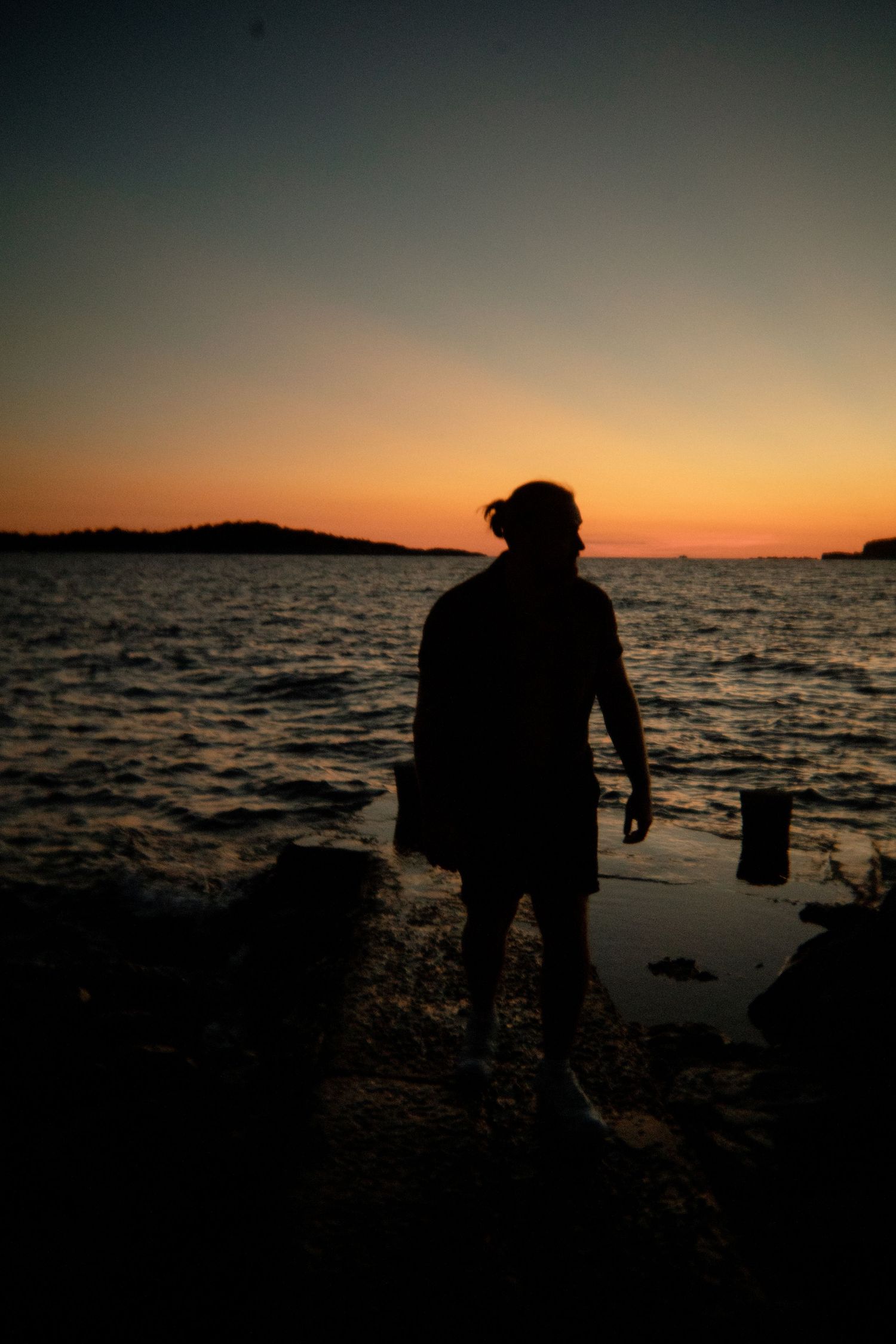 Silhouettes against a dramatic orange sunset over the ocean. Croatia.