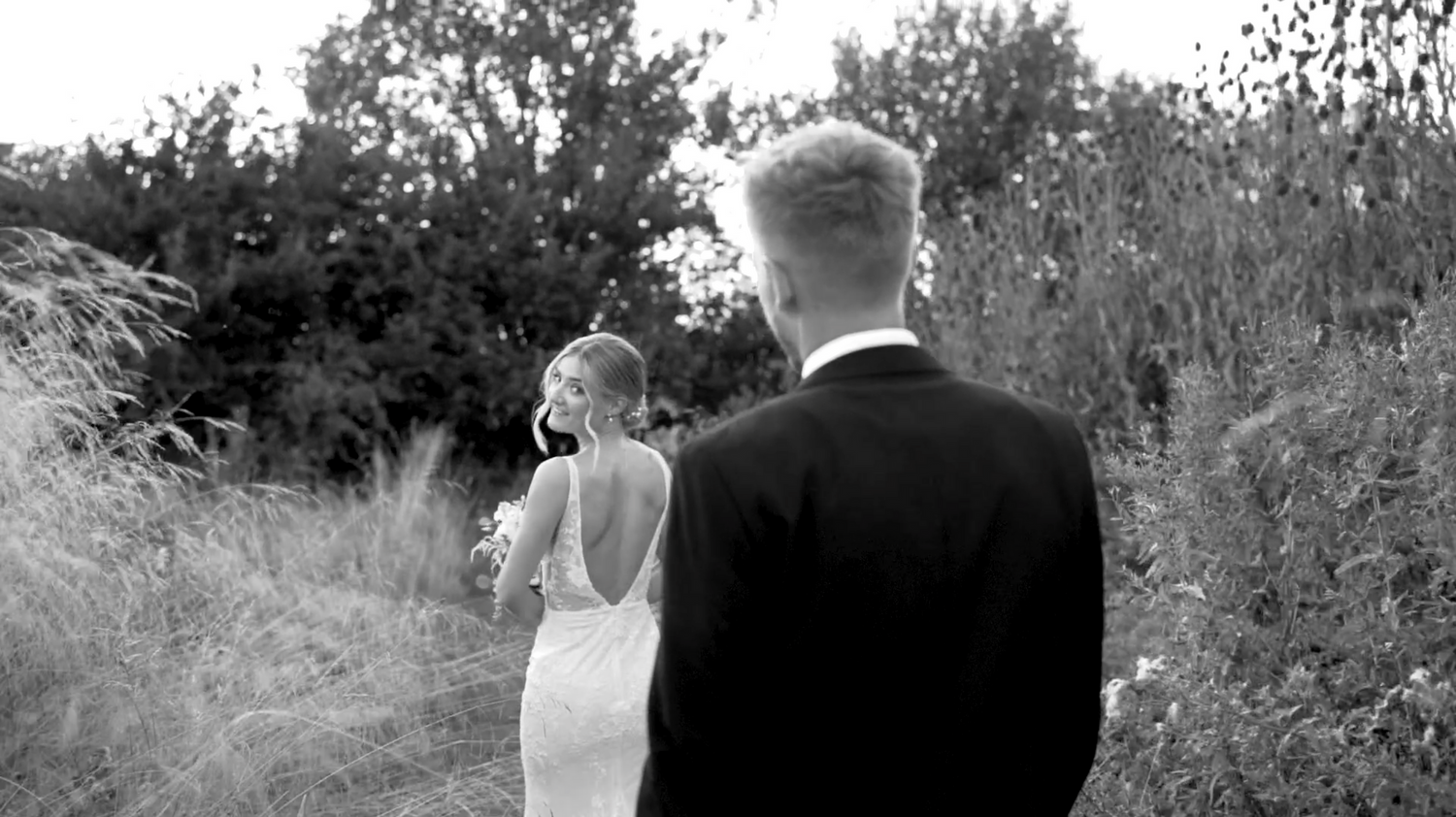 Wedding party walks together outdoors in black and white photography. Villiers Barn, Thorpe-le-Soken.