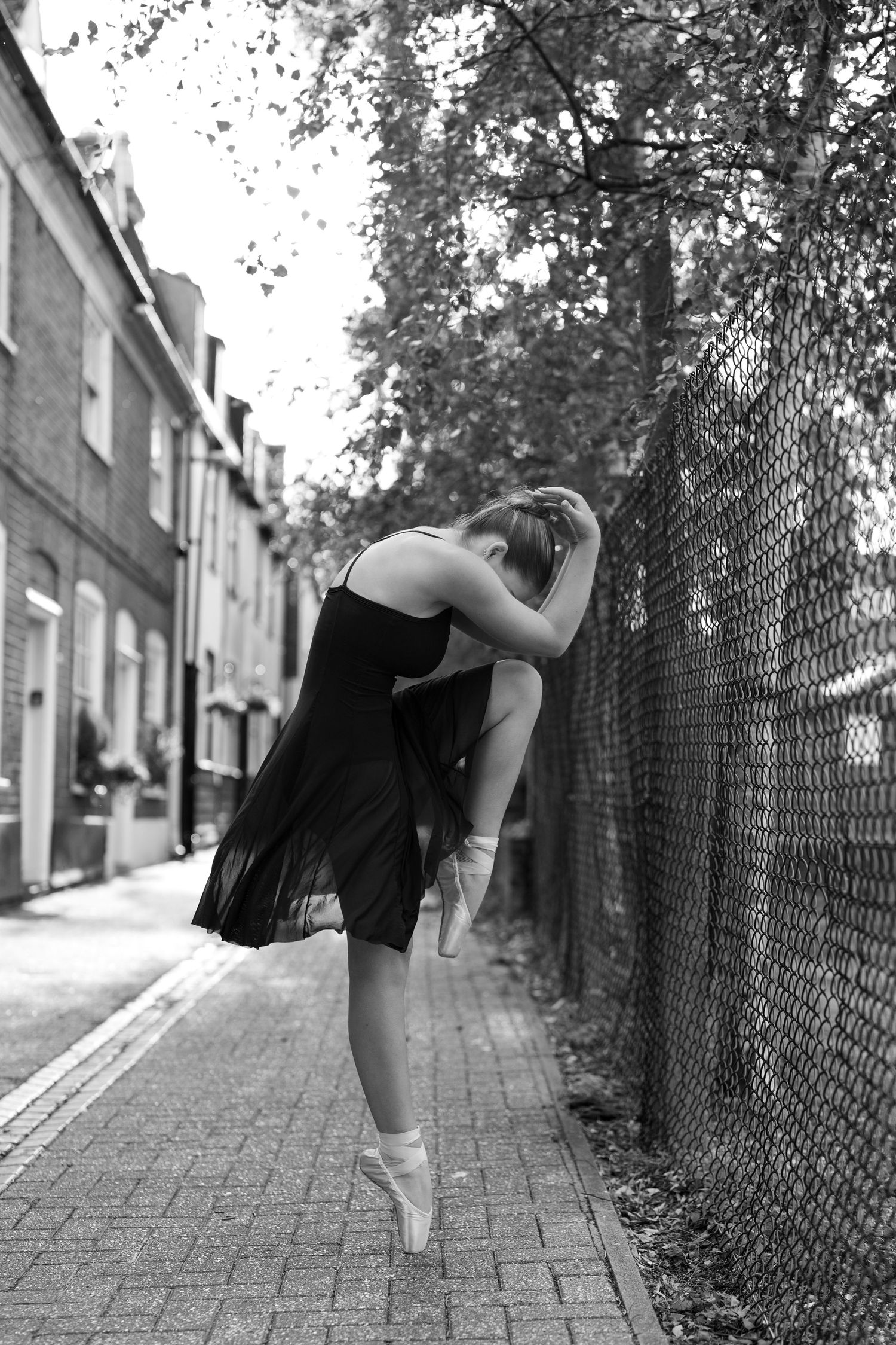 Black and white series of dance poses showing graceful movements along an urban pathway. Old Harwich, Essex.