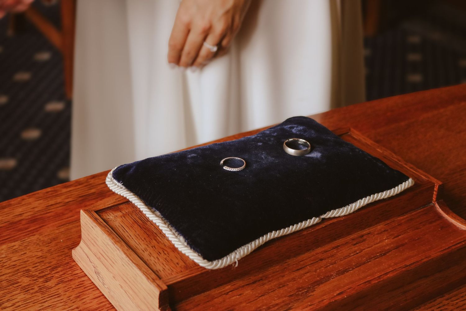 Seven sequential photos show a black electronic device gradually sliding off a wooden table surface.