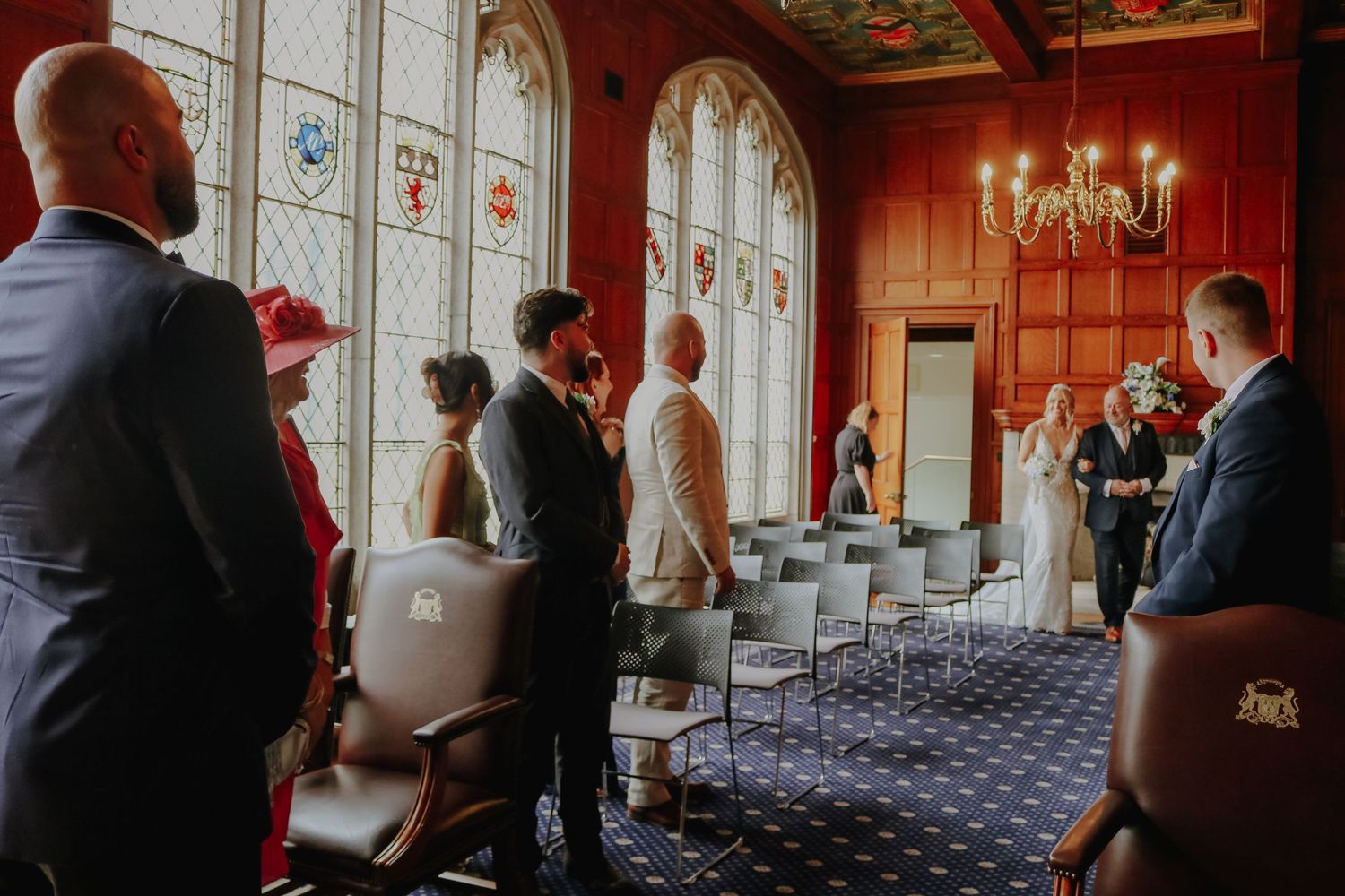 Interior of a historic venue with stained glass windows and classic wooden decor setup for a wedding ceremony.