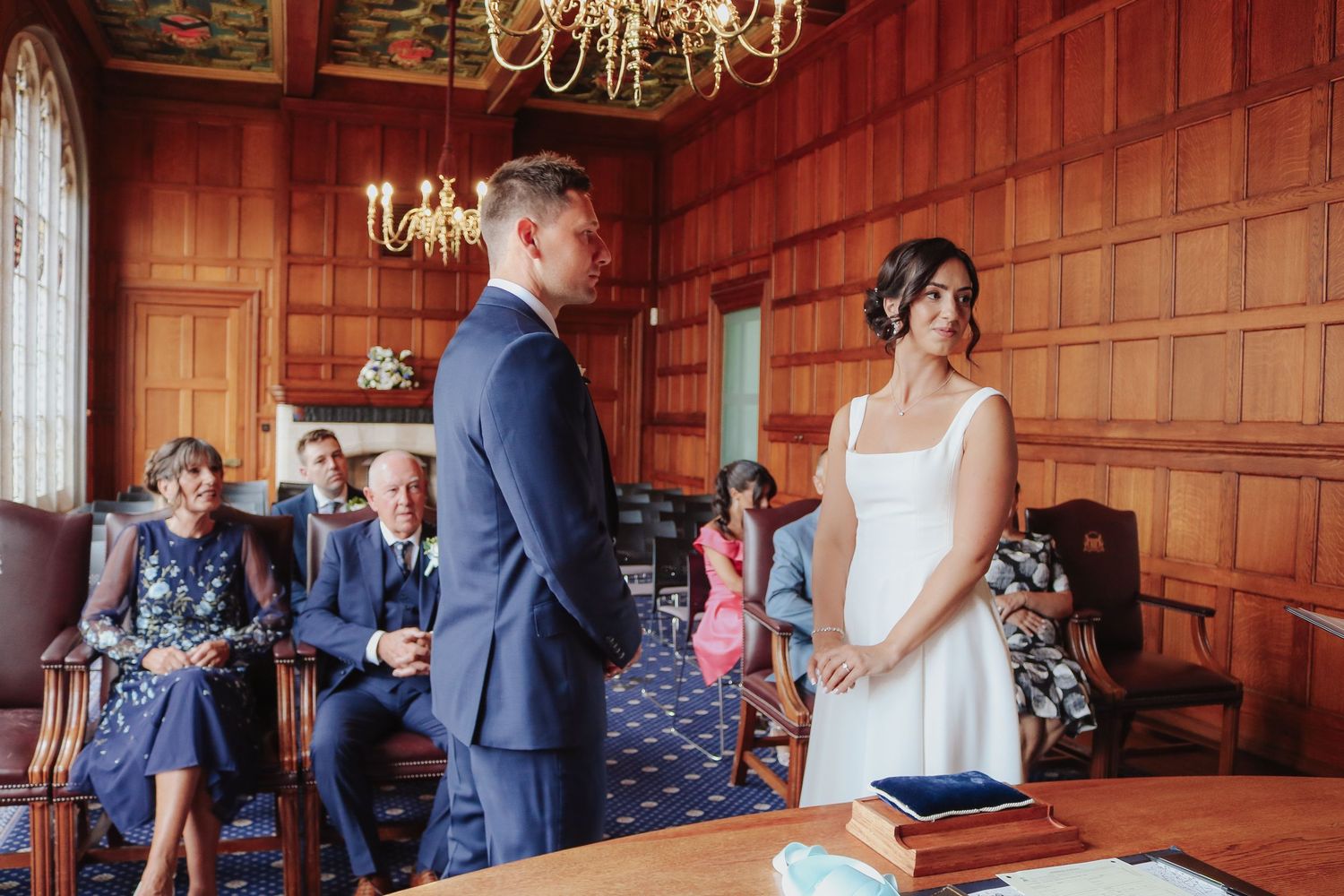 Three sequential photos show a traditional wood-paneled meeting room during a small gathering event.