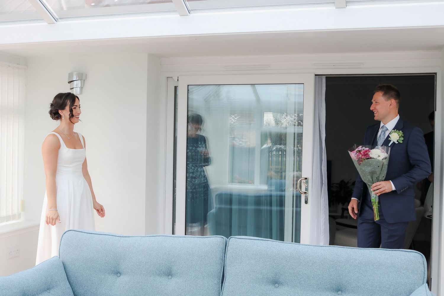 A sequence of wedding photos showing the first look between a couple in a bright white indoor setting.