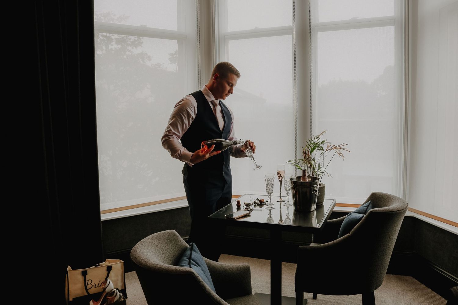 Person looking down at camera in modern minimalist dining room with black chairs and large windows.