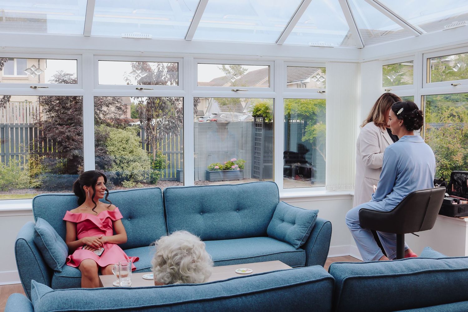 Sequence showing a startup sequence of someone reclining comfortably on a modern teal couch in a bright sunroom.