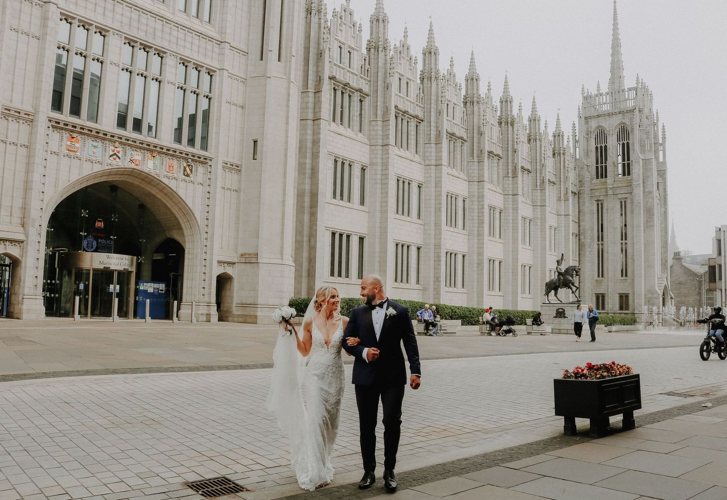 A newlywed couple celebrates outside the magnificent stone facade of Marischal College in Aberdeen.