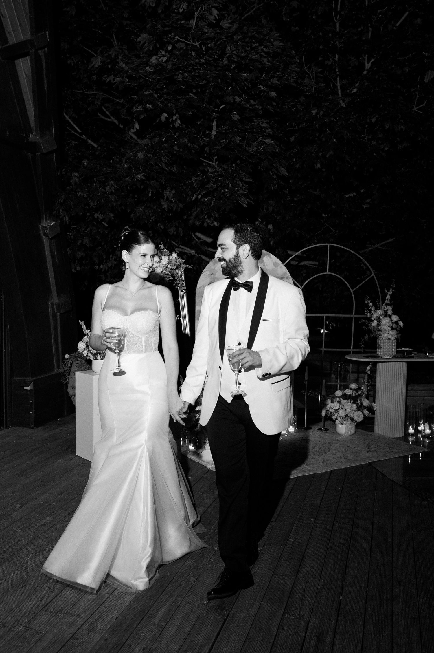 A bride and groom share a romantic dance together at their outdoor evening wedding reception.
