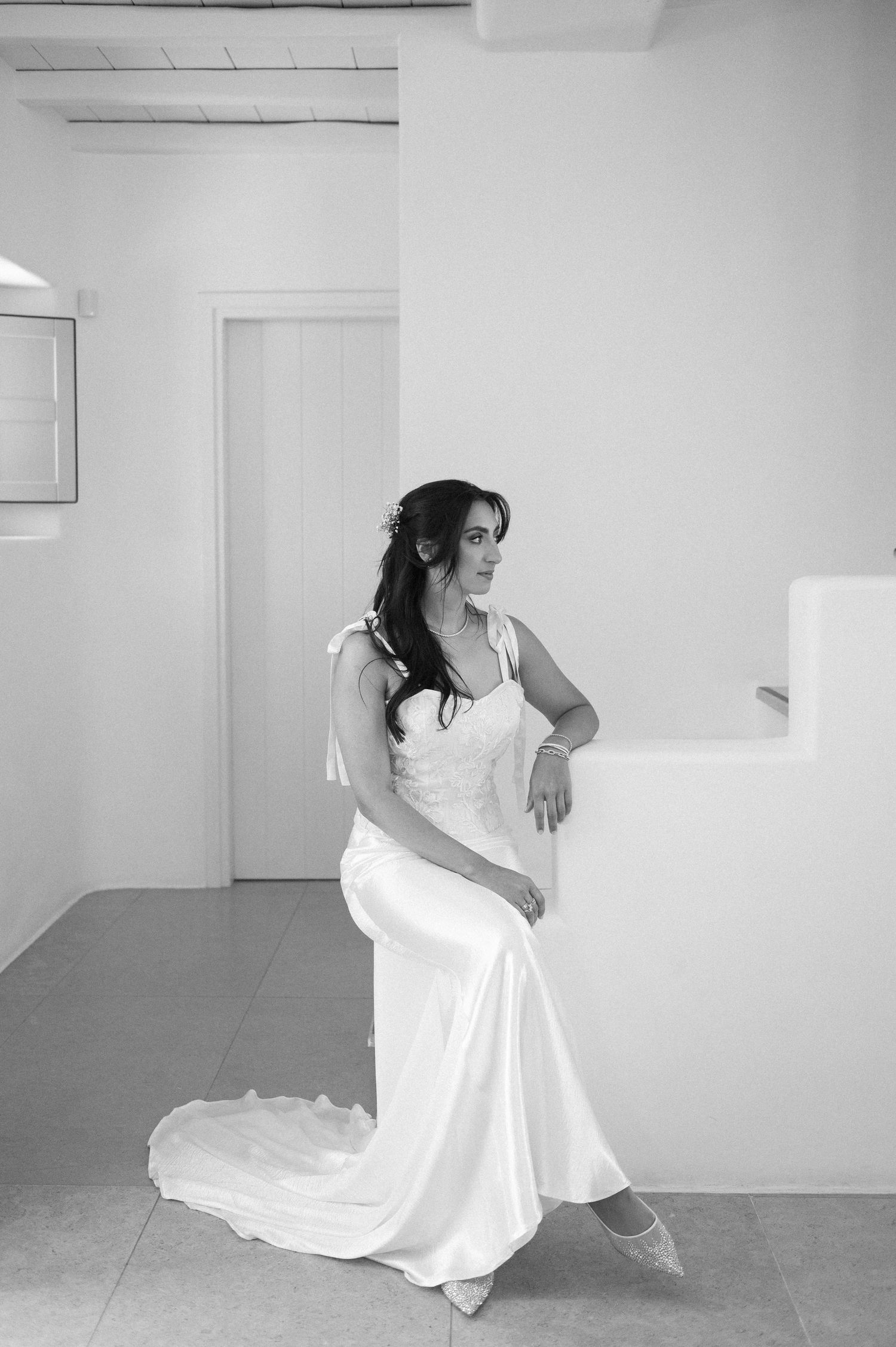 A figure in a flowing white dress performs an expressive modern dance sequence in a minimalist studio space.