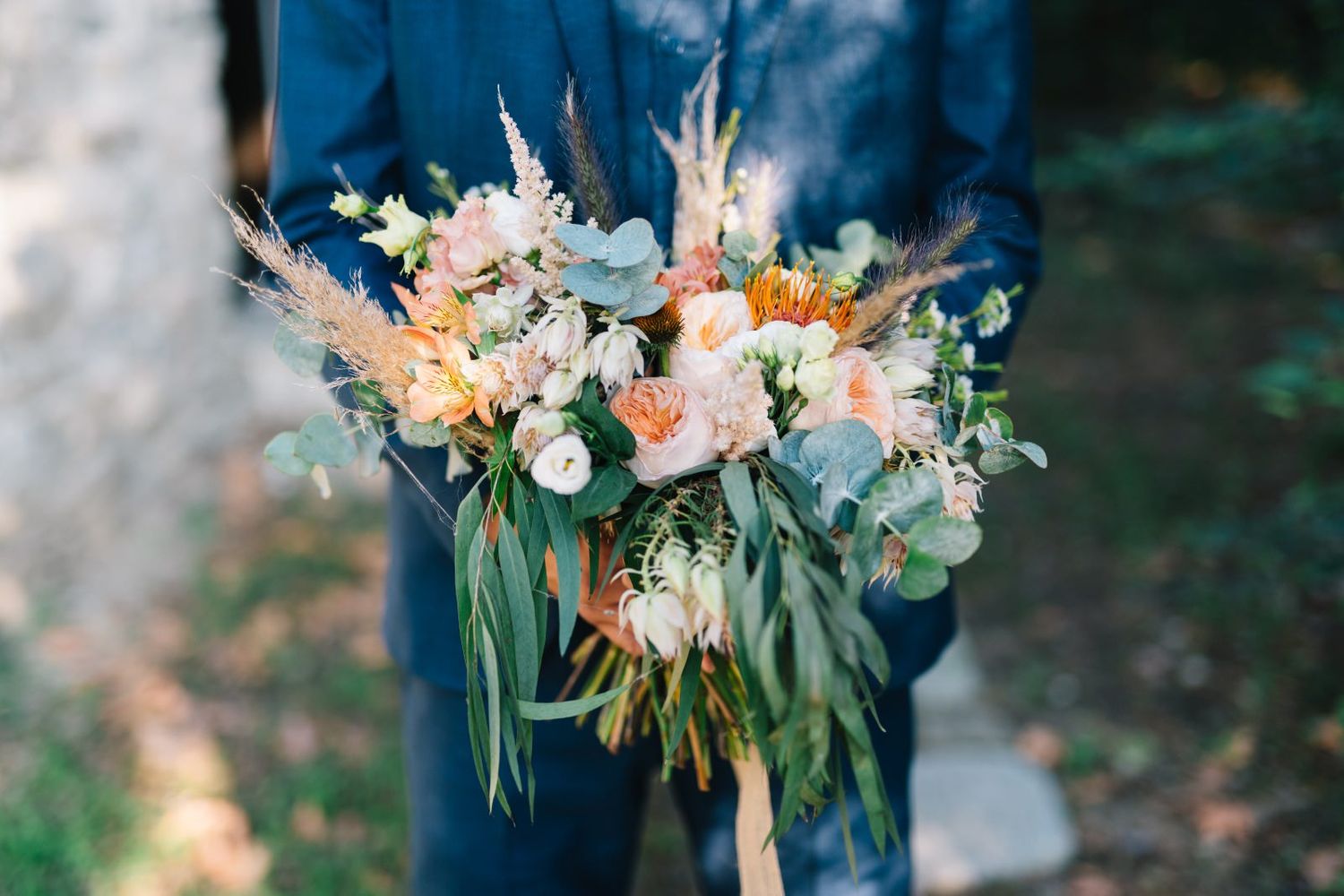 groom is waiting the bride with the wedding bouquet