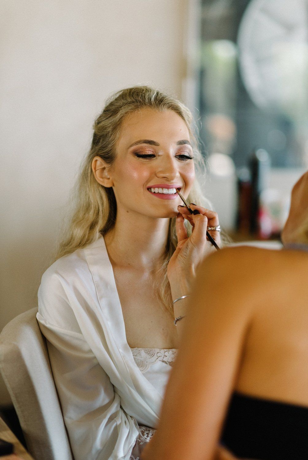 Makeup application during wedding day preparations.