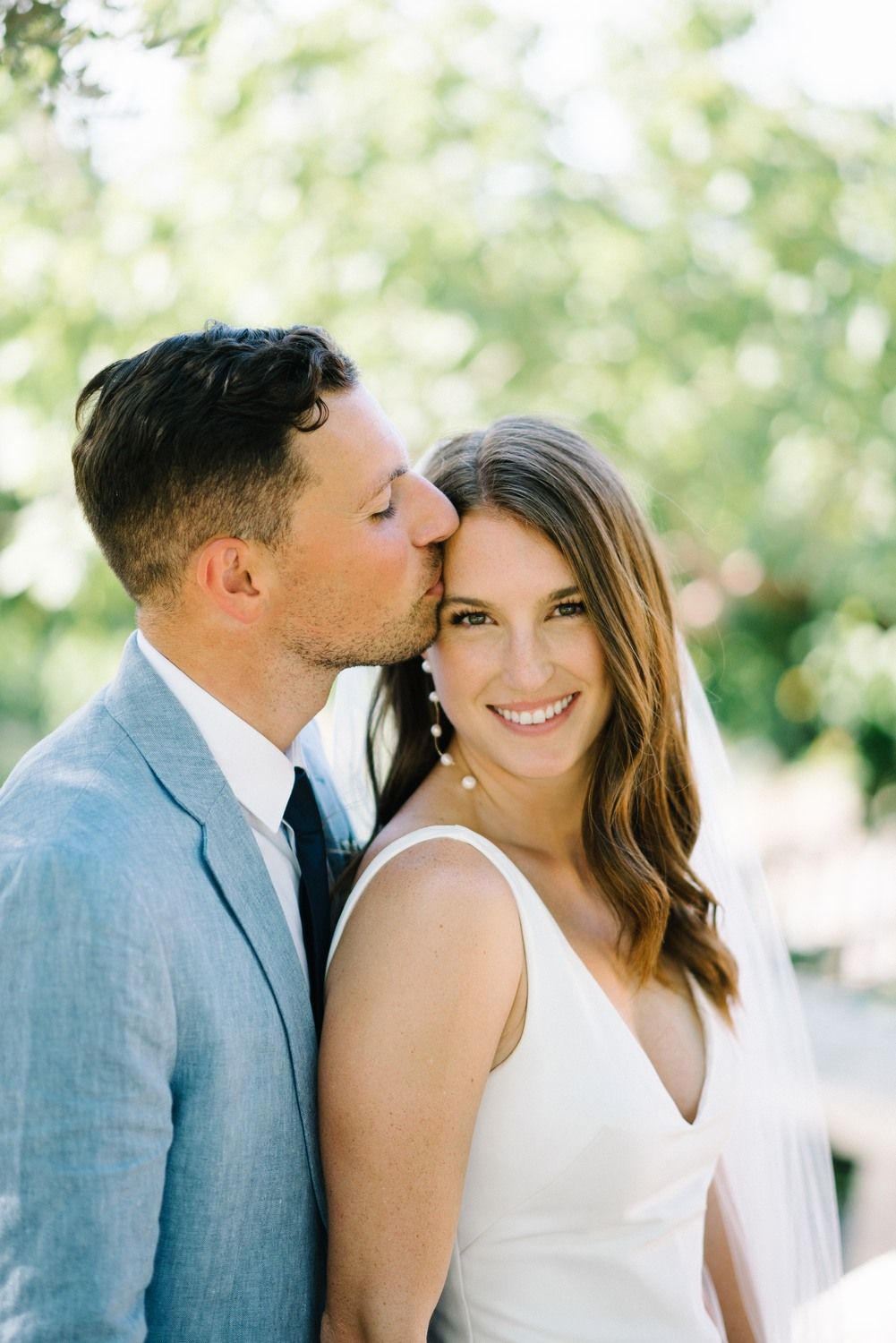 bride and groom kissing at forehead